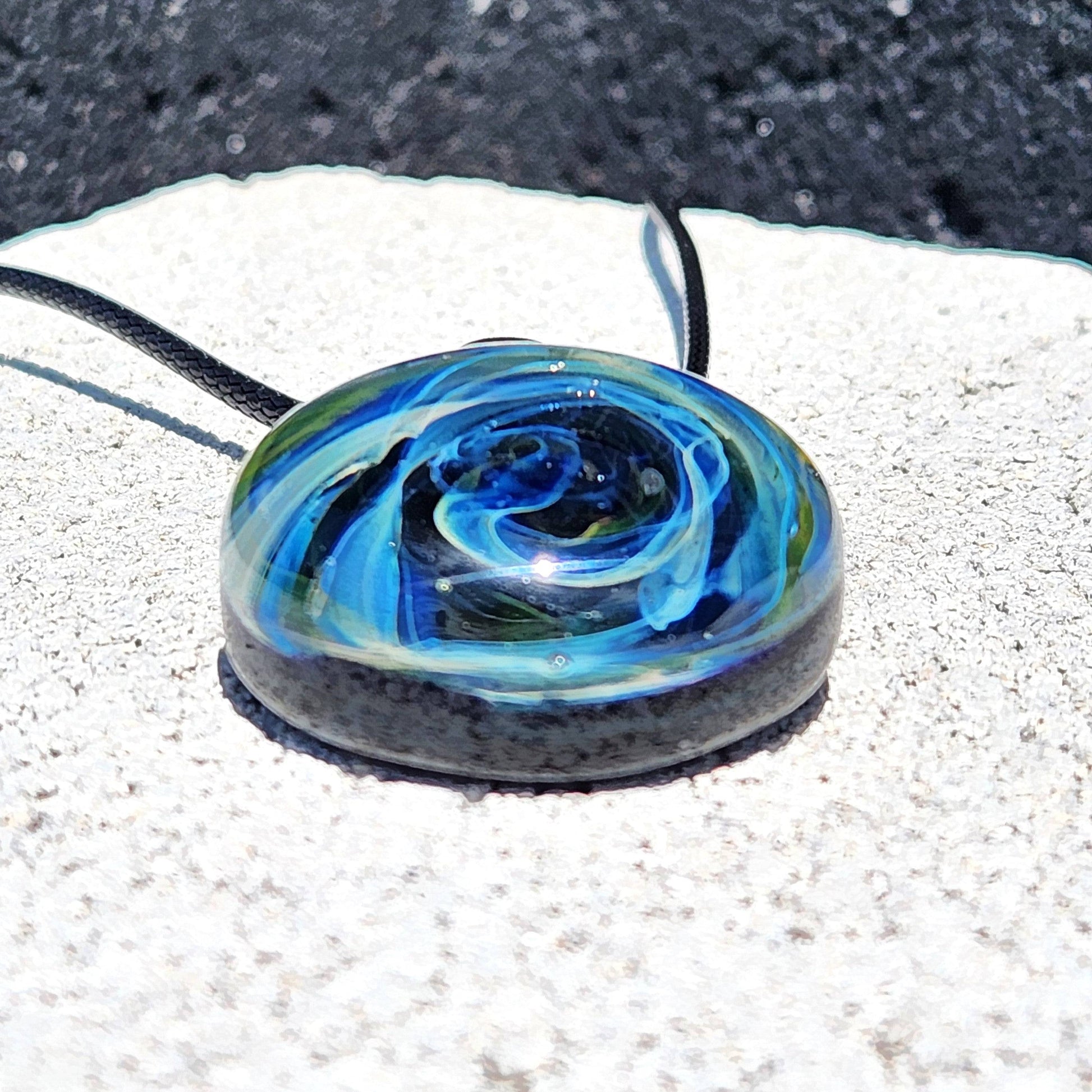 Flat view of Heady Glass Pendant showcasing its vibrant galaxy-inspired design with blue and gold swirls, crafted in borosilicate glass.