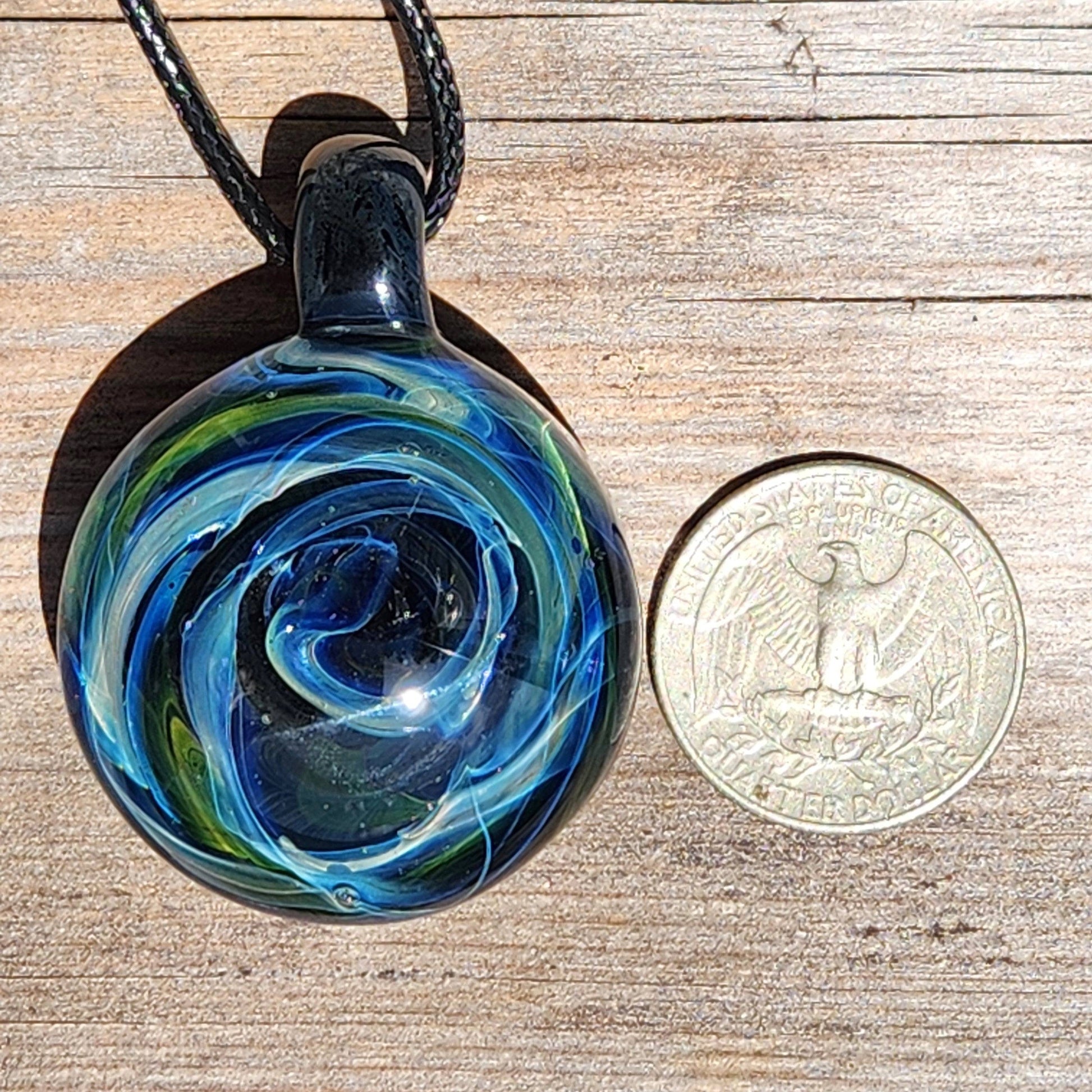 Size comparison of Heady Glass Pendant next to a U.S. quarter, highlighting its large size and intricate handmade galaxy design.