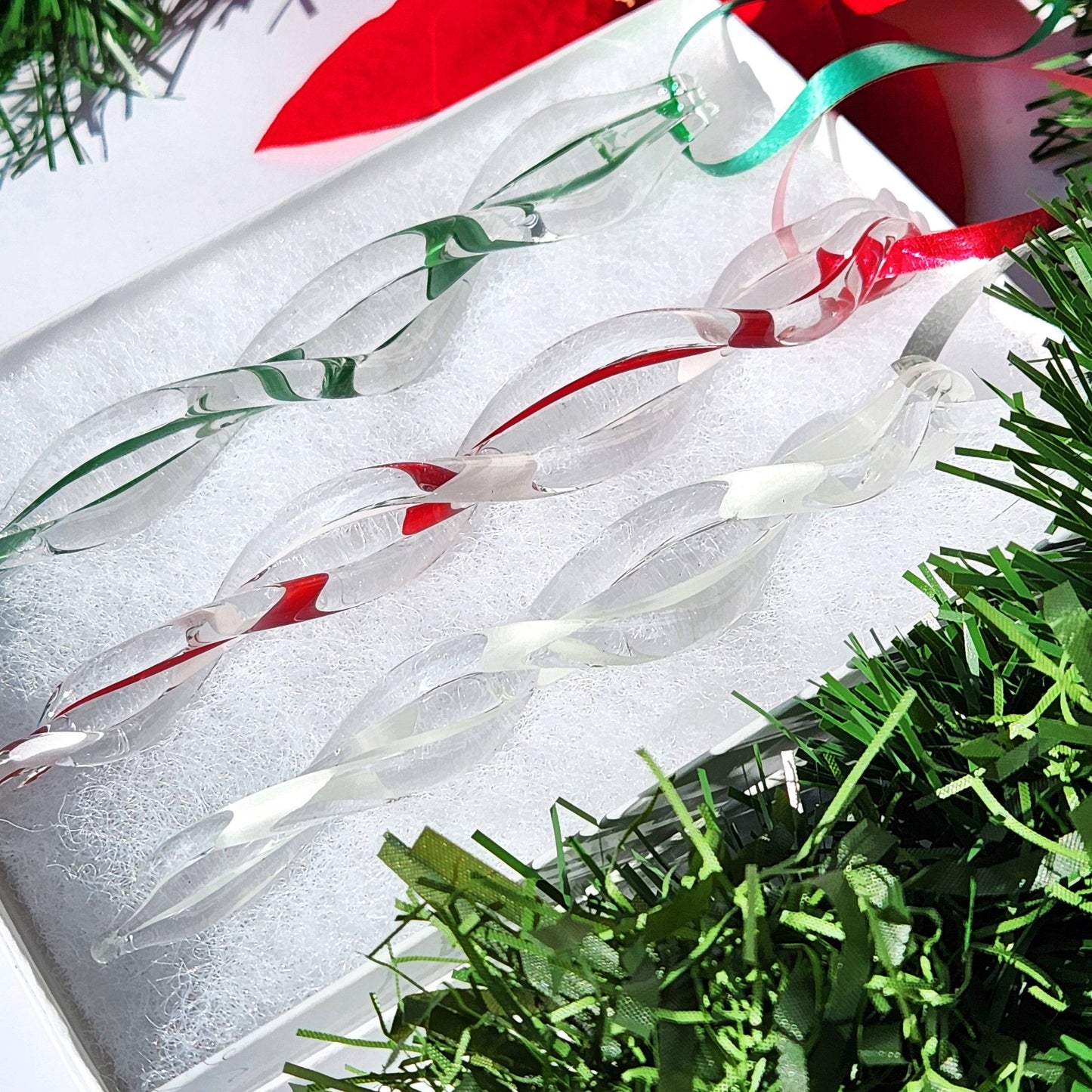 Set of red, green, and white handmade glass icicles in a gift box, ideal for Christmas tree ornaments or festive presents.