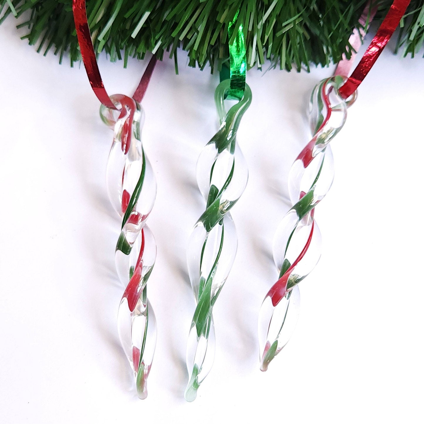 Three red and green handmade glass icicle ornaments hanging from garland, perfect for festive home decor and holiday gifts.