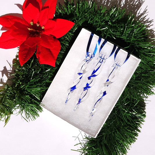 Set of 3 blue glass icicle ornaments displayed in a white box with green garland and red poinsettia, ideal for handmade Christmas decorations.