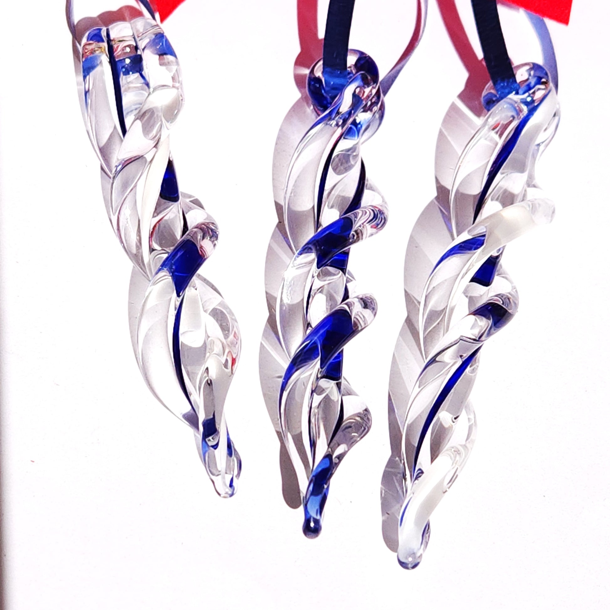 Detailed view of twisted blue and clear glass icicle ornaments, showcasing the craftsmanship of these handmade Christmas decorations.