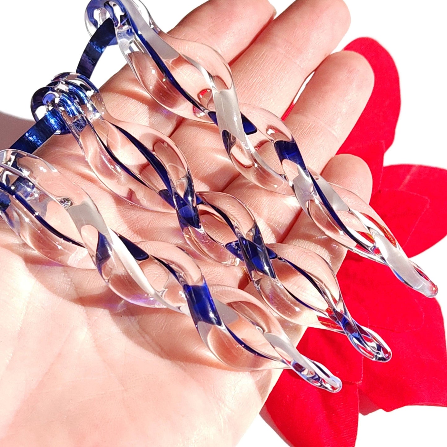 Hand holding five blue handmade glass Christmas icicles, showcasing the detailed twist design for elegant holiday decoration.