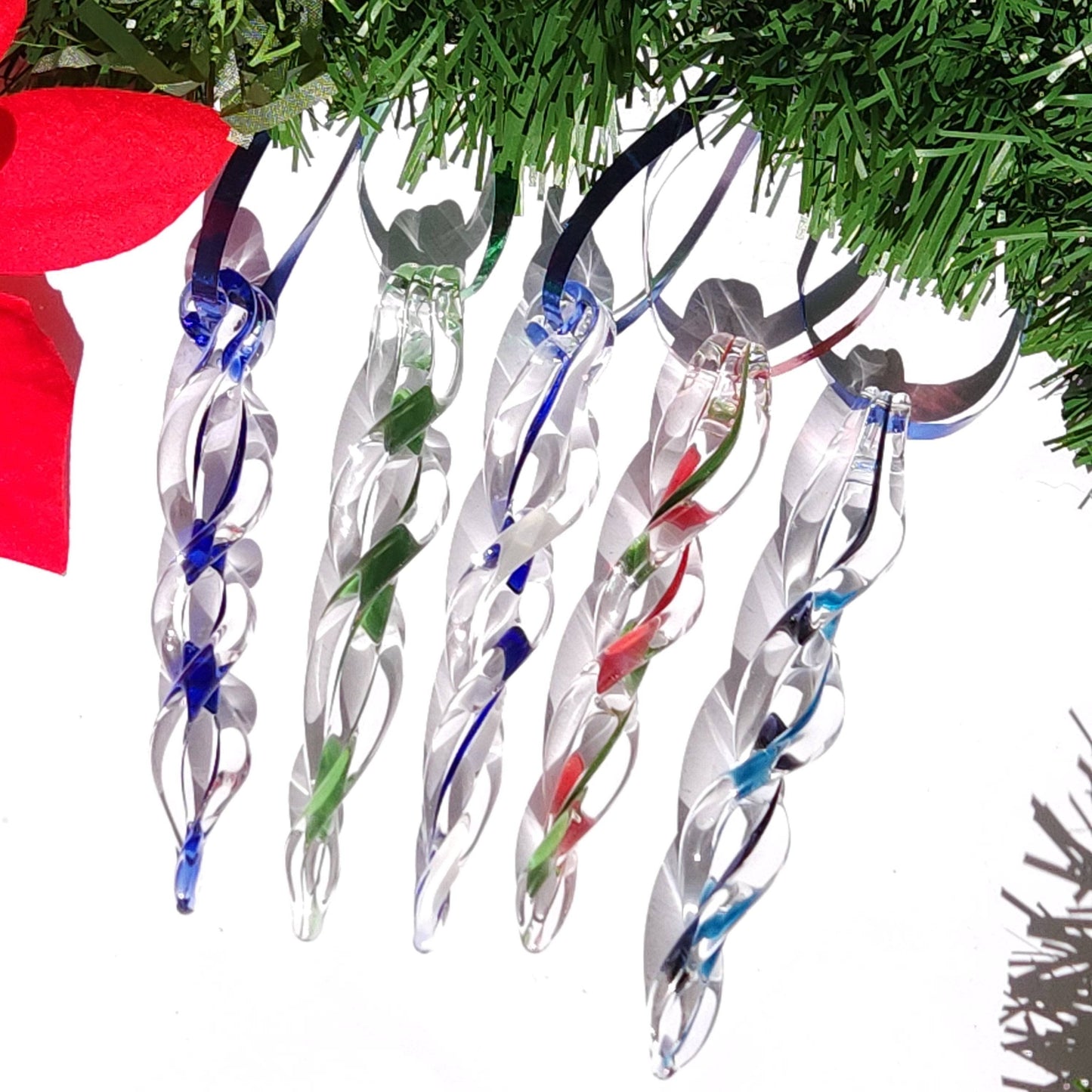 Five handmade glass Christmas ornaments in blue, green, and red, featuring twisted icicle design for elegant holiday decor.