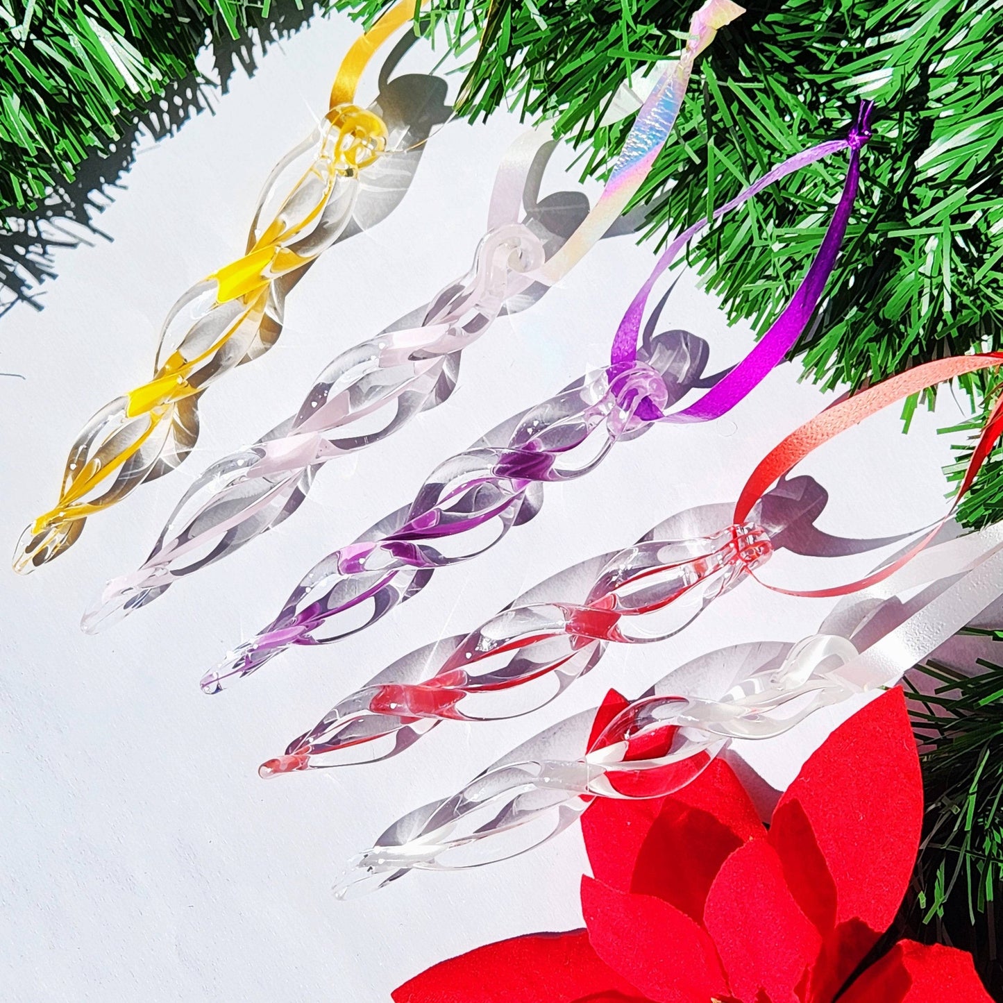 Five colorful handmade glass icicle ornaments in yellow, pink, and purple, ideal for festive home decoration and holiday gifting.
