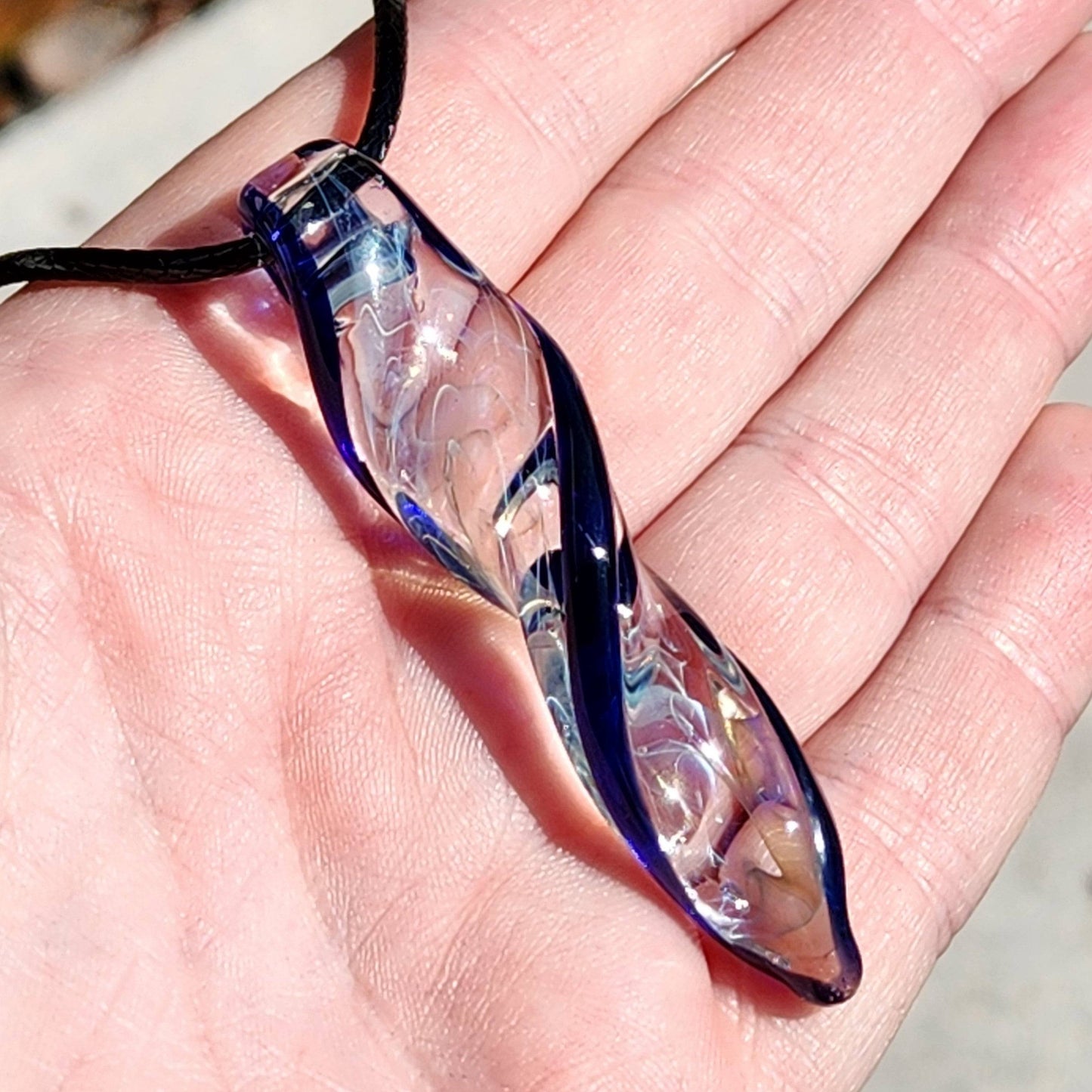 Blown Glass Spiral Pendant – Silver Fumed Design with Blue Accents, shown in hand to highlight clarity and craftsmanship.