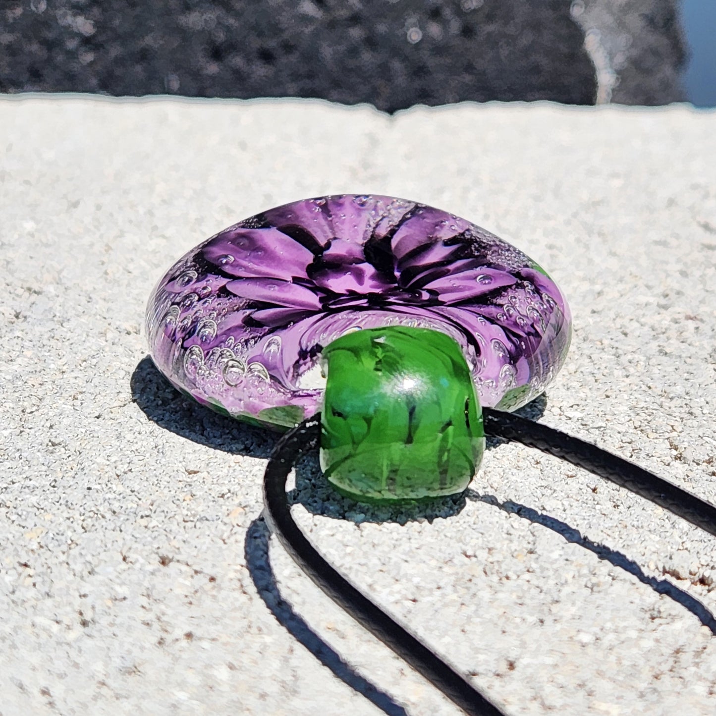 Handmade Borosilicate Glass Pendant: Purple and Black on a Green Background
