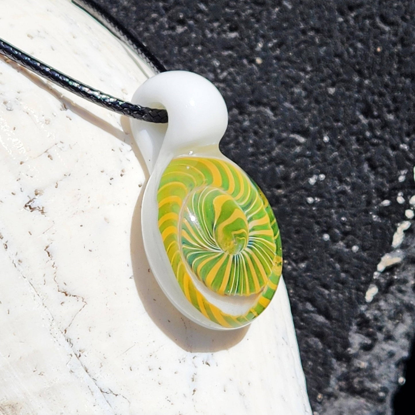 Angled view of Handmade Spiral Glass Pendant with bold green-yellow spiral, ideal for gifting unique blown glass jewelry.