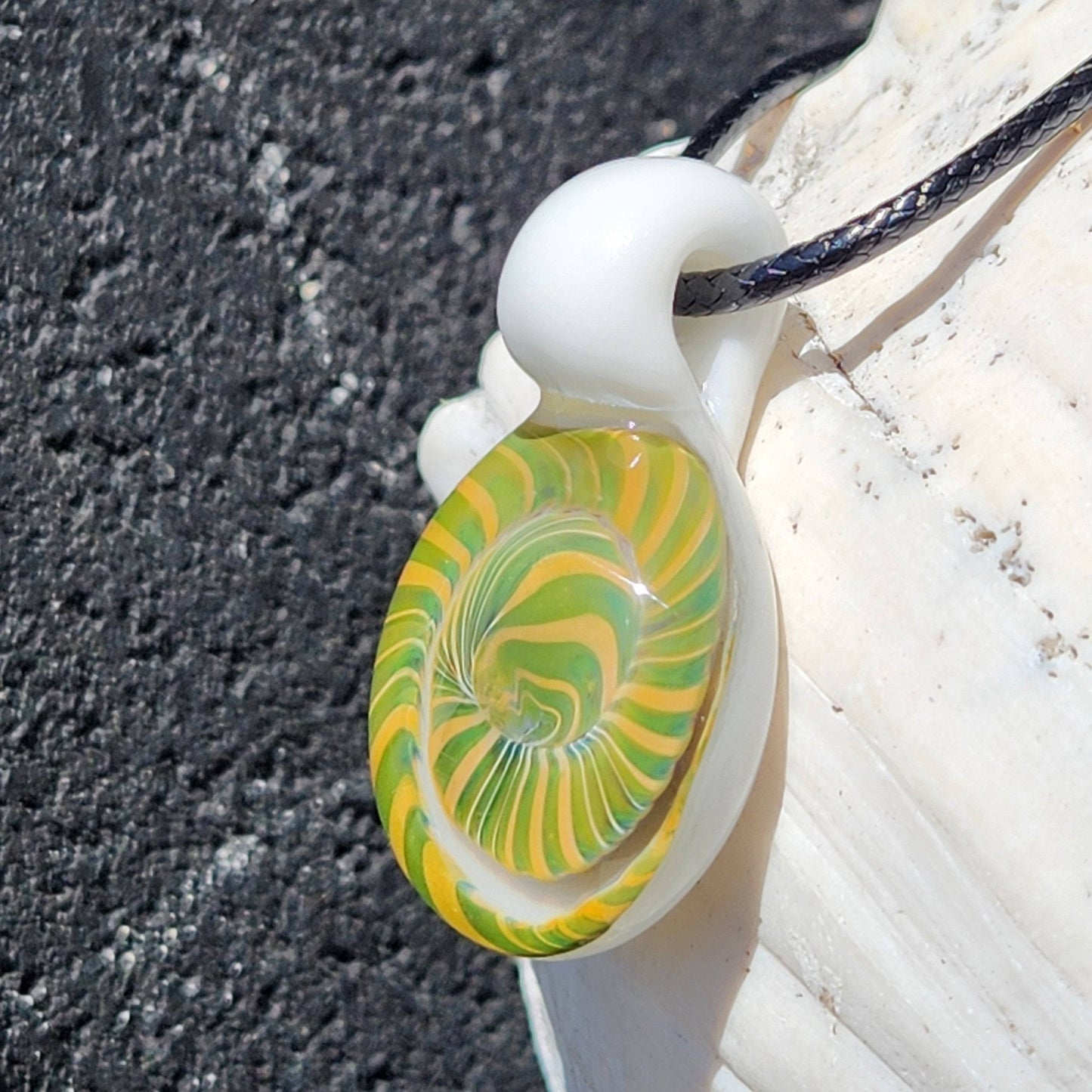 Handmade Spiral Glass Pendant hanging on black cord, featuring a green-yellow swirl and white top, ideal for jewelry collections.