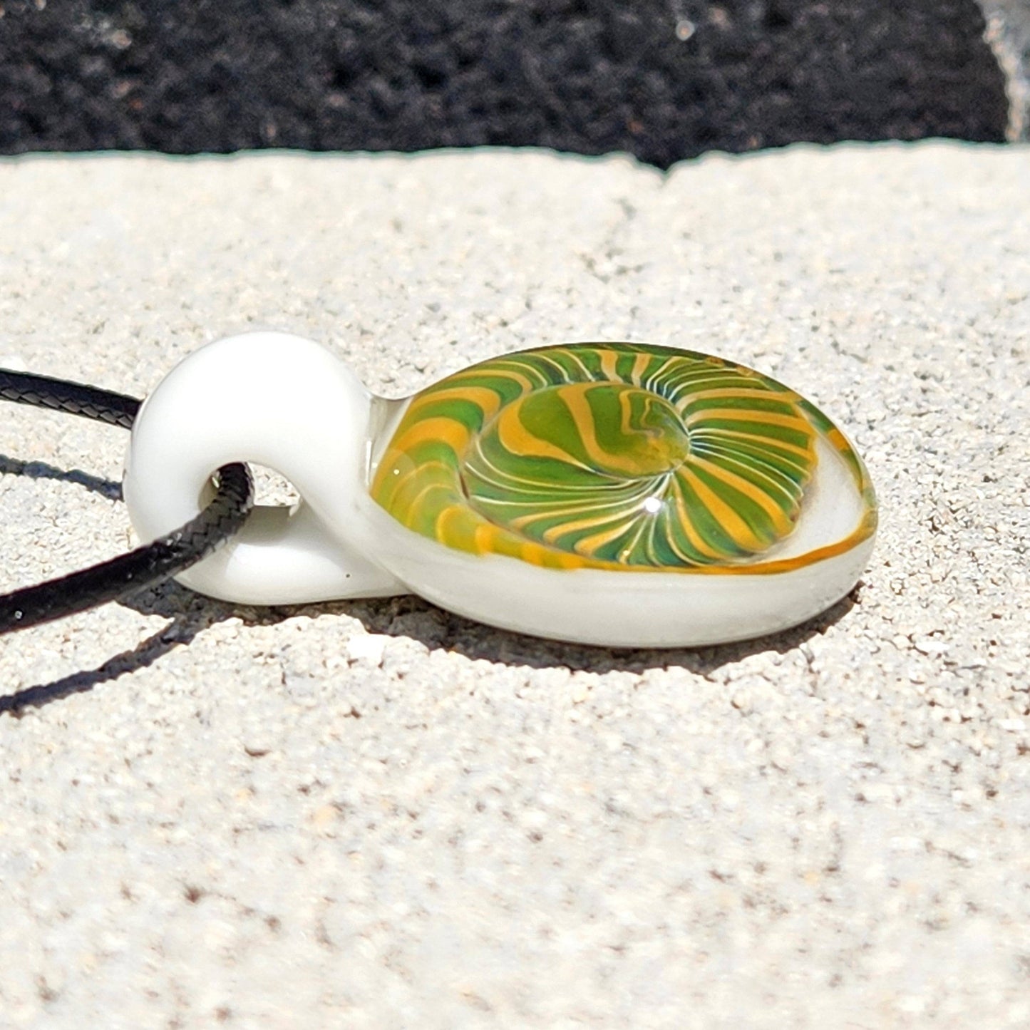 Flat side view of Handmade Spiral Glass Pendant with yellow and green spiral, emphasizing its handcrafted borosilicate glass detail.