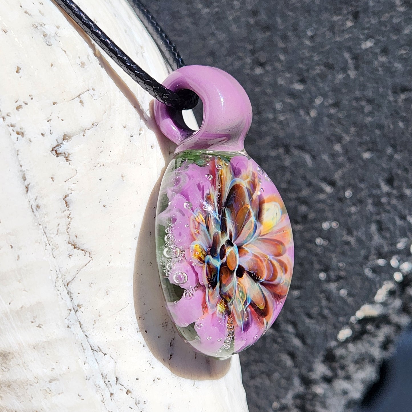 Handcrafted multicolor glass pendant with purple loop and detailed floral core. Unique borosilicate jewelry for fashion accessories.