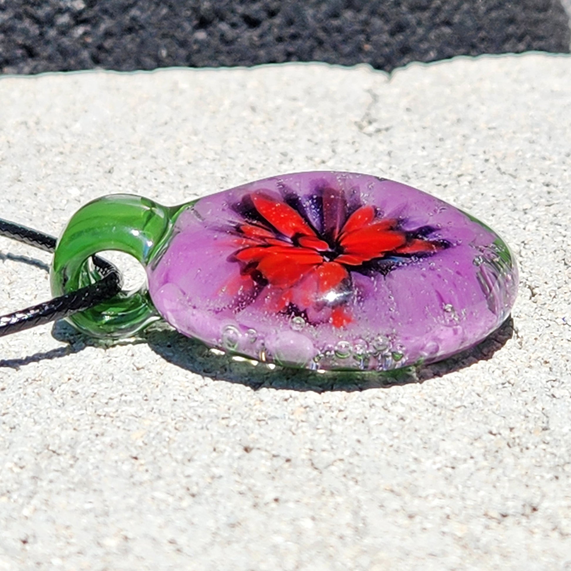Artistic Large Heady Glass Pendant Necklace with floral design in red, purple, and black. Handmade green glass pendant with bubble detailing.