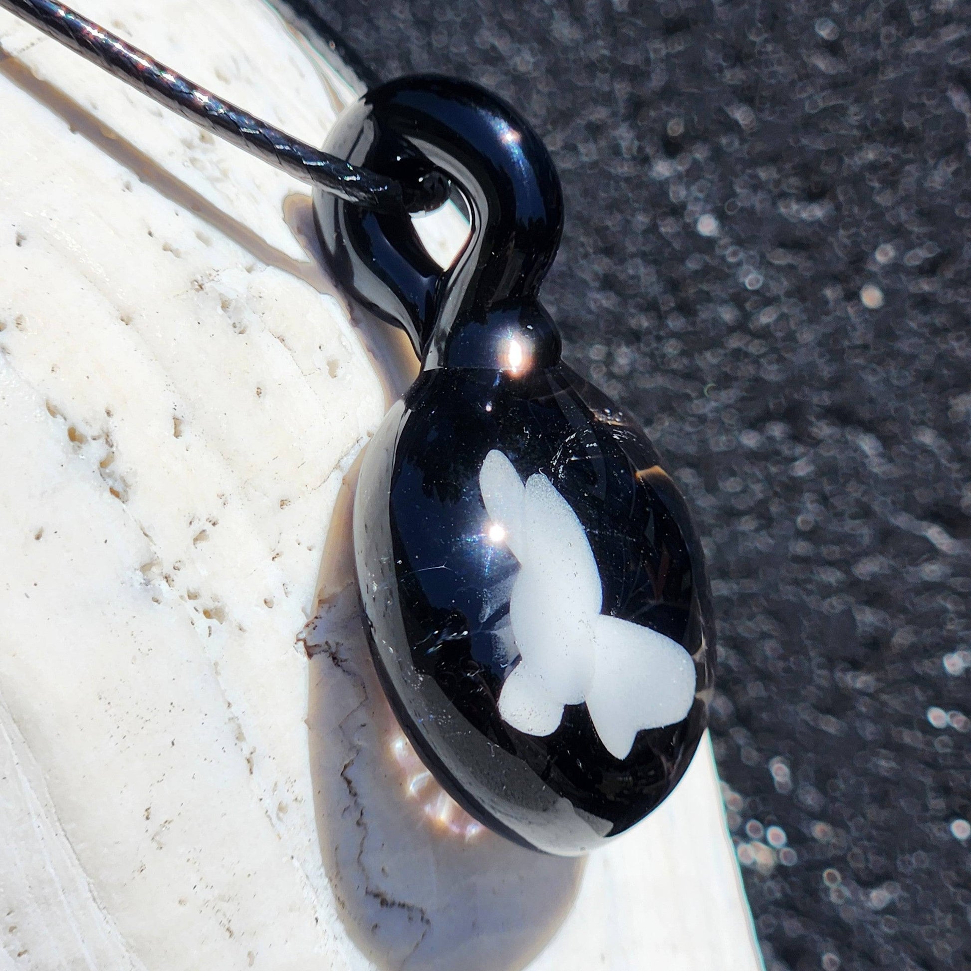 Close-up of Small Black and White Glass Pendant with butterfly design, handmade statement jewelry made in the USA.