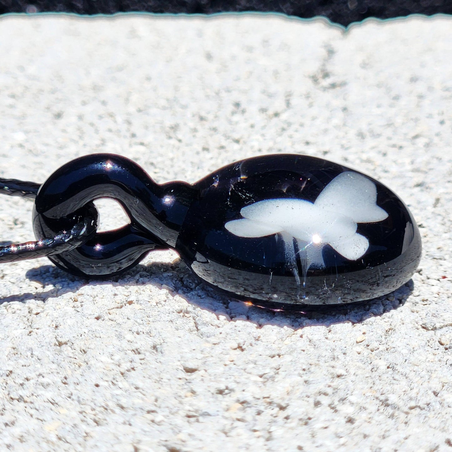 Side view of Small Black and White Glass Pendant showing glossy finish and white butterfly detail, ideal for statement jewelry lovers.