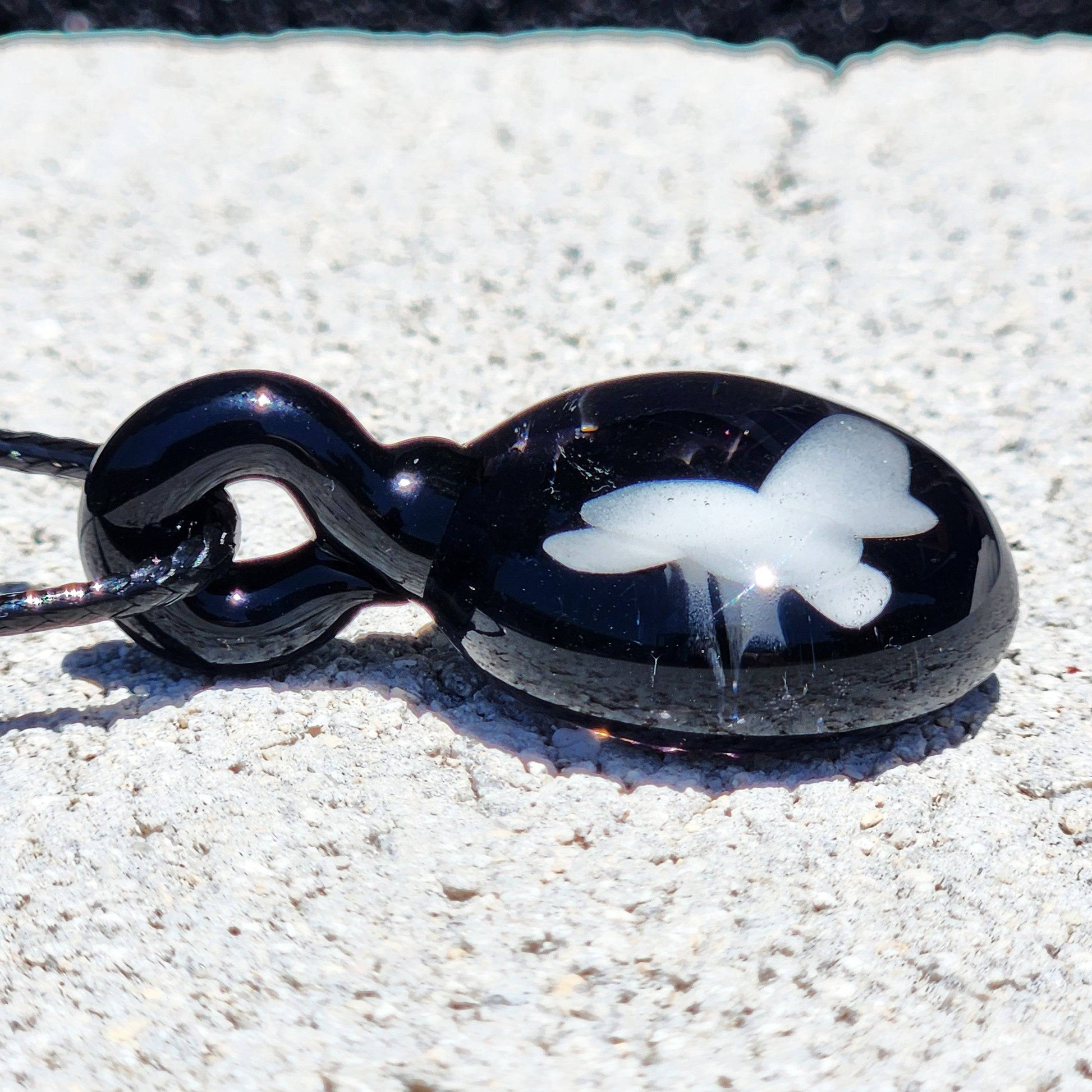 Side view of Small Black and White Glass Pendant showing glossy finish and white butterfly detail, ideal for statement jewelry lovers.