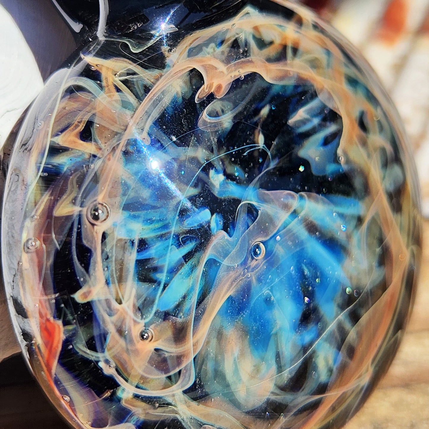 Close-up on a glass pendant with pure silver fuming and ocean blue crushed glass