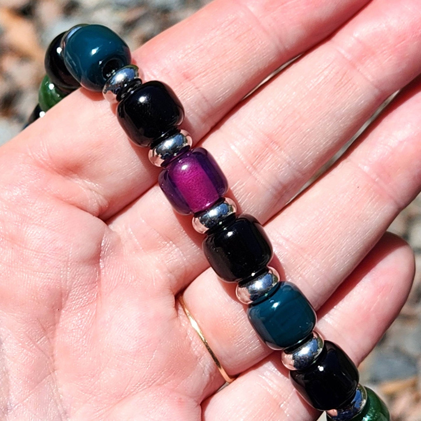 Close-up of Boho Glass Beaded Bracelet in hand, highlighting the purple and teal glass beads with silver spacers.