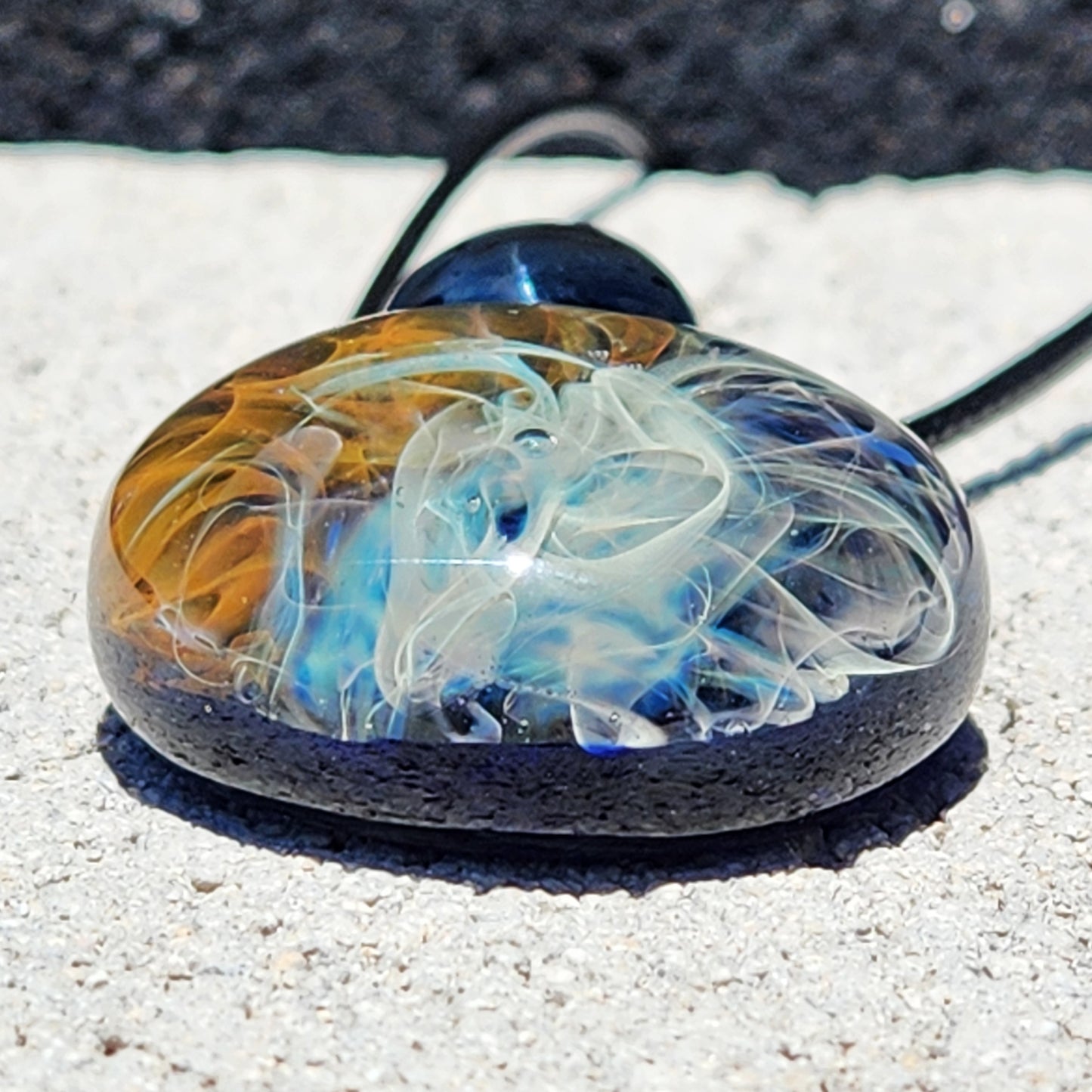Bottom view of Gold & Silver Fumed Glass Pendant Necklace showing depth of implosion design. Unique handmade jewelry with cosmic effect.