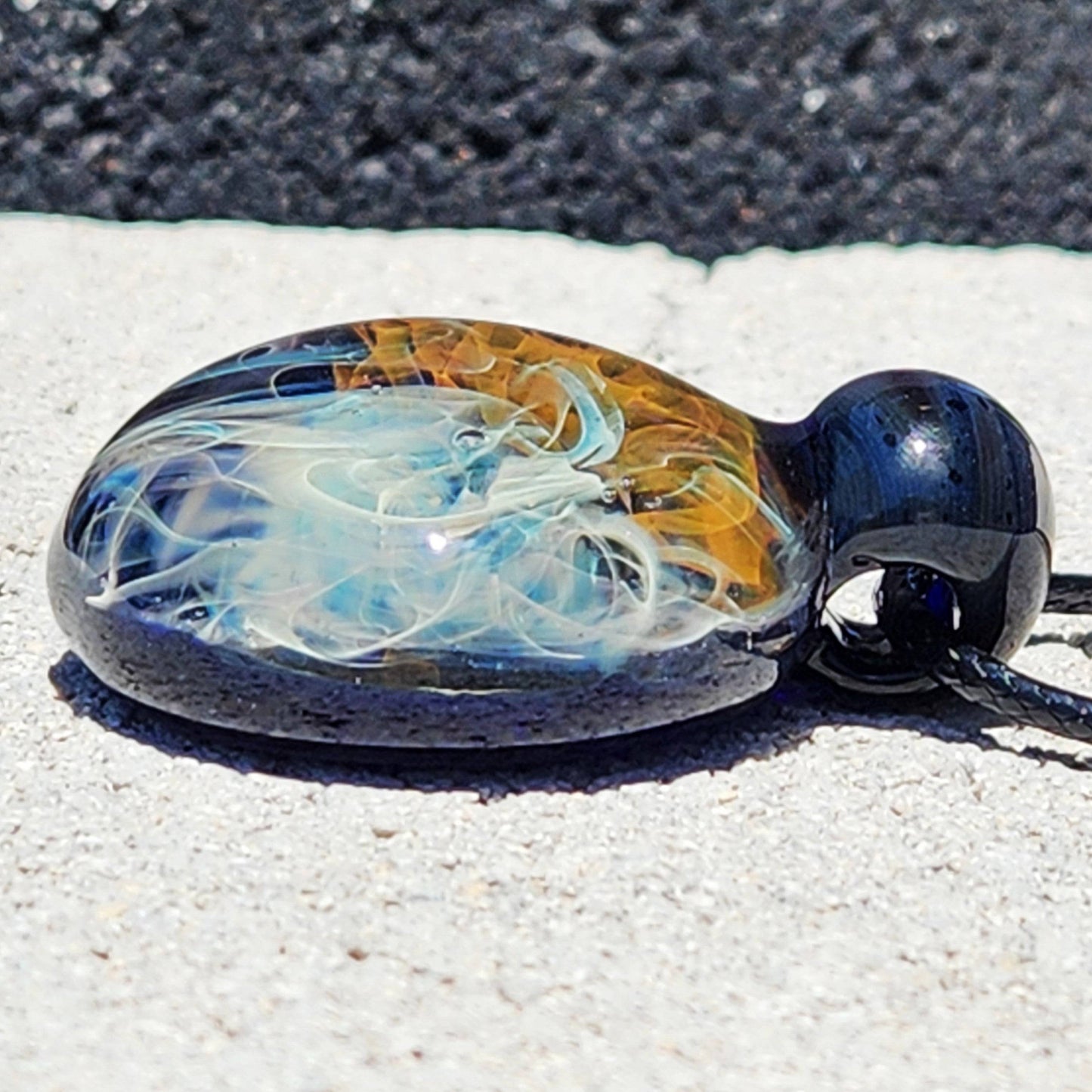 Flat view of Gold & Silver Fumed Glass Pendant Necklace showing layered glass art. Handcrafted pendant with blue, gold, and silver accents.