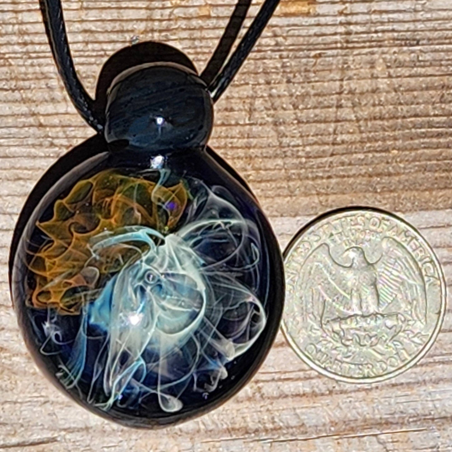 Gold & Silver Fumed Glass Pendant Necklace next to a US quarter for size reference. Handblown pendant with intricate galaxy-style design.