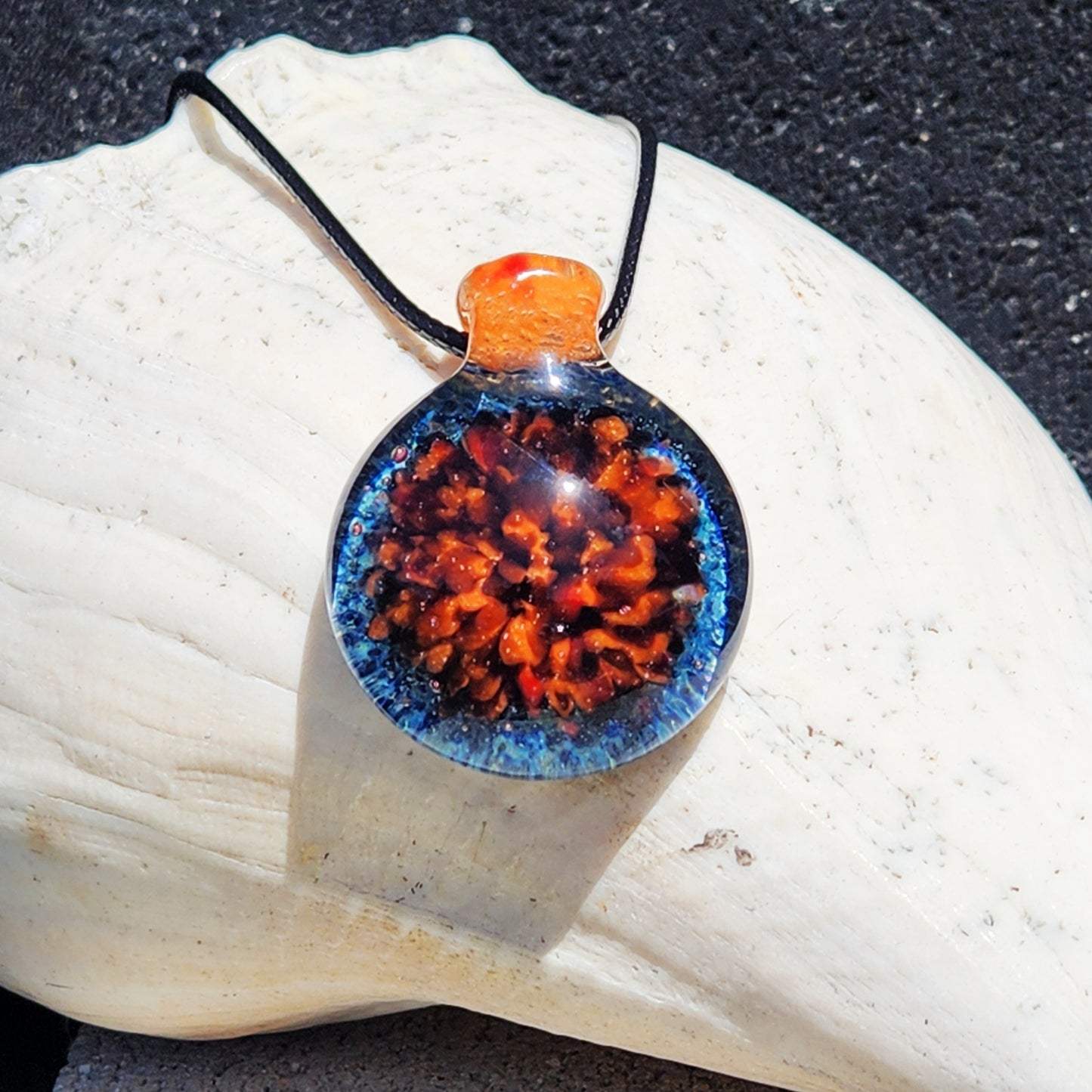 Gift-ready handmade glass pendant featuring multicolor crushed borosilicate, displayed on a white seashell. Unique necklace for jewelry lovers.