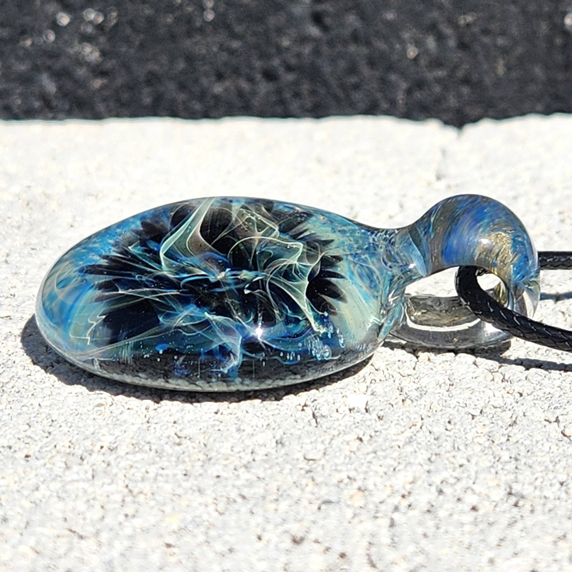 Flat view of Handmade Pendant Necklace – Winter Scene Borosilicate Glass Pendant showing detailed silver and blue color patterns.