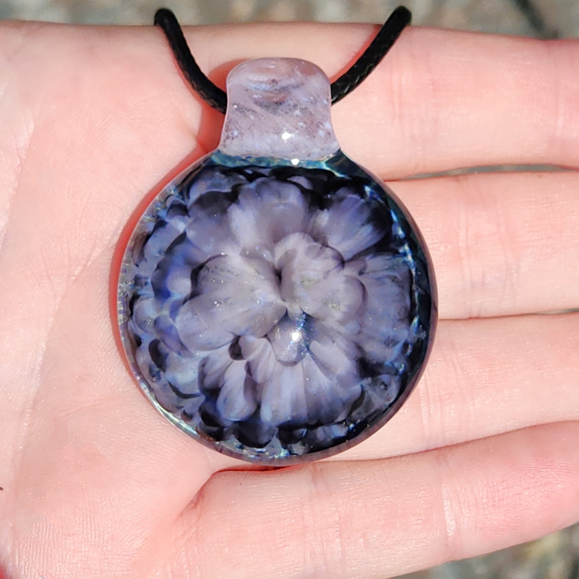 Pink flower pendant necklace held in hand to show scale and detail of the handmade crushed glass floral design.