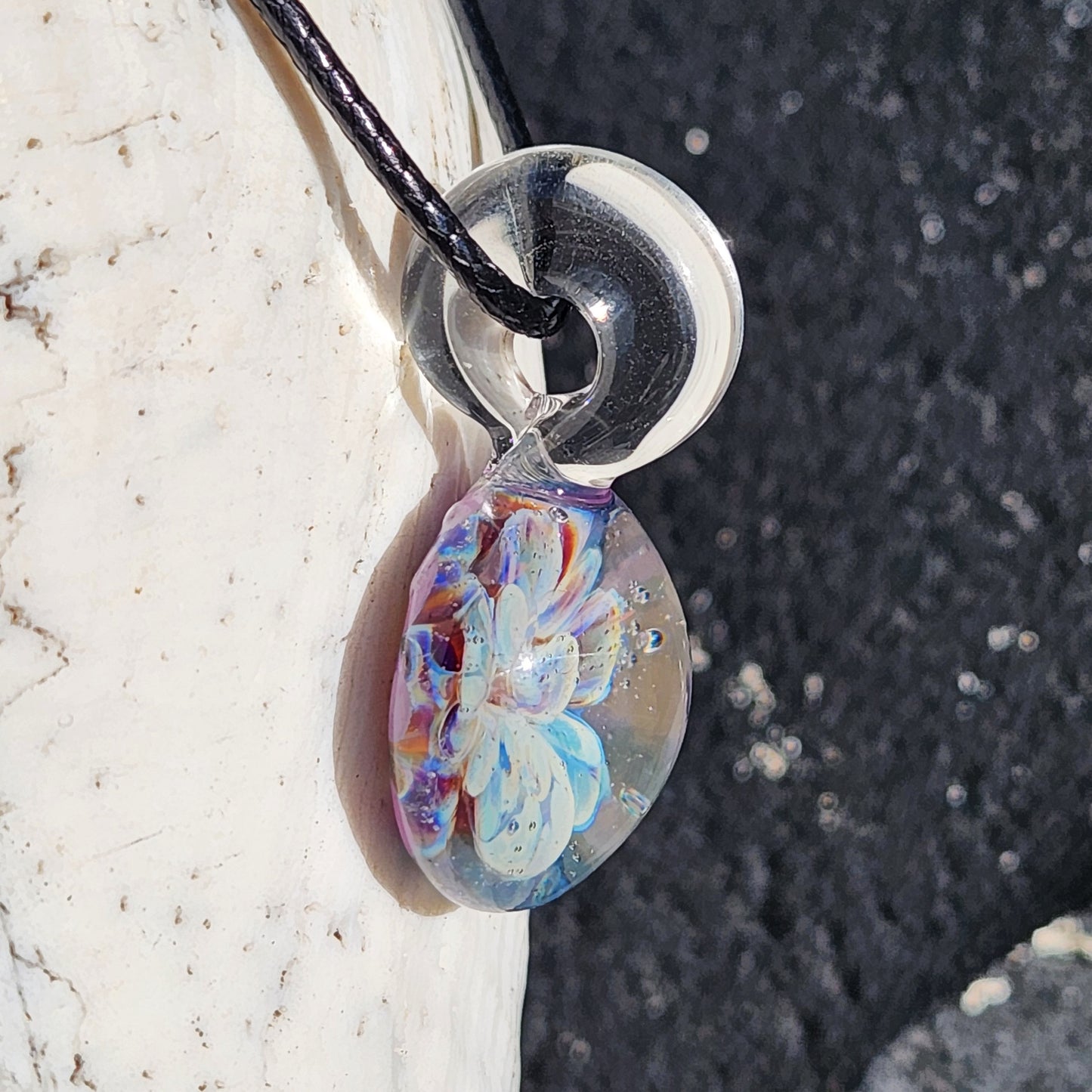 Side angle of Handmade Borosilicate Glass Pendant highlighting the clear loop and layered blue-purple flower design.