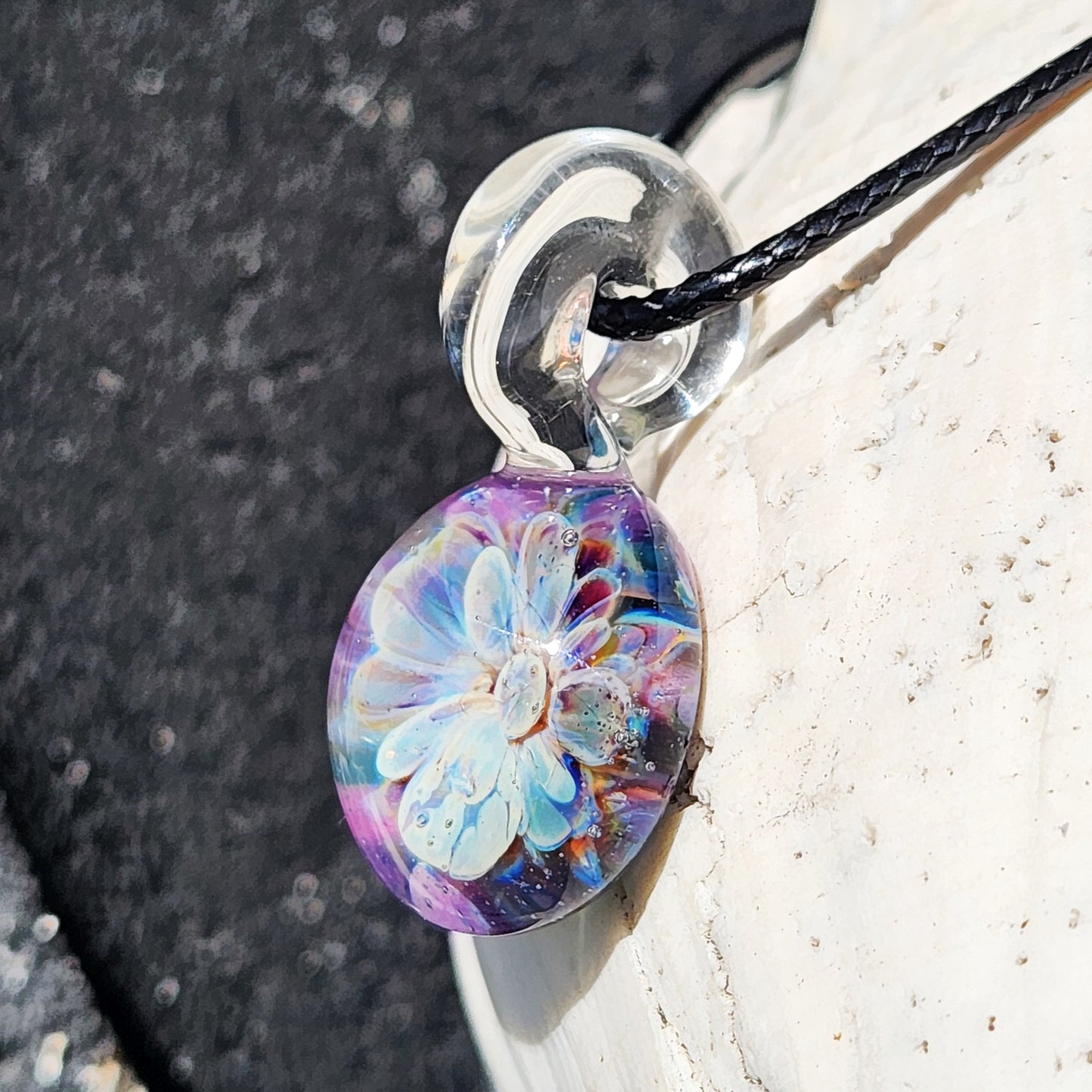 Angled view of Handmade Borosilicate Glass Pendant with detailed blue and purple bloom and clear glass loop.