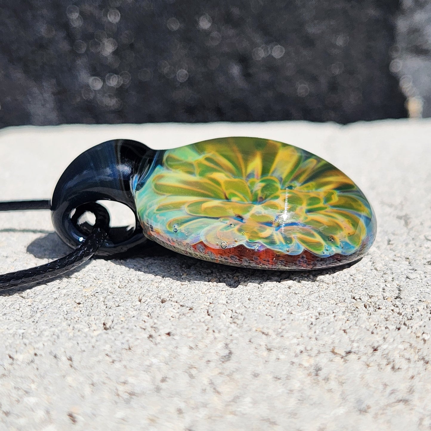 Side profile of handmade glass pendant showing intricate yellow-green floral design. Unique necklace gift in jewelry pendants category.