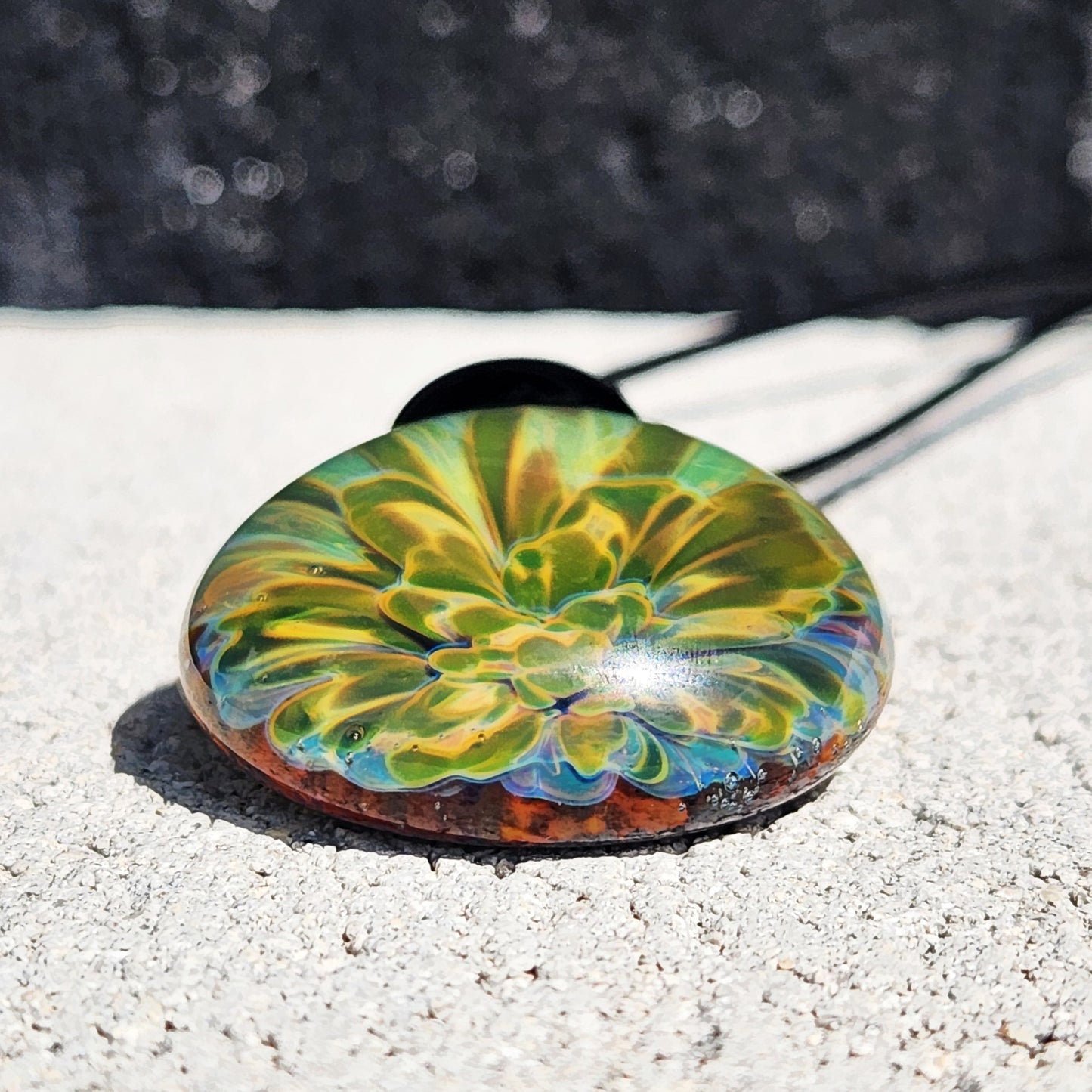 Bottom view of handmade glass pendant with vibrant yellow-green flower pattern. Comes in gift box, perfect for jewelry lovers.