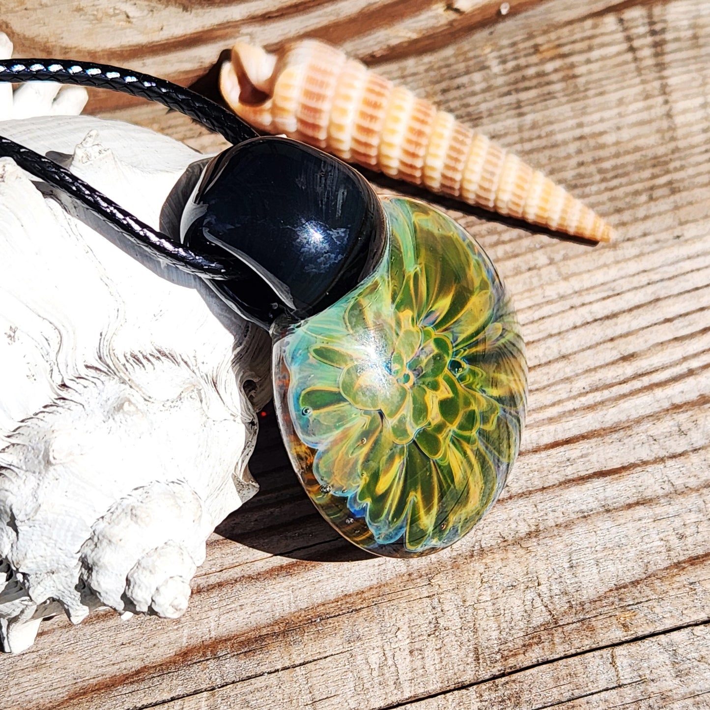 Yellow-green borosilicate glass pendant with black loop, displayed with seashells. Handmade necklace in apparel & accessories category.