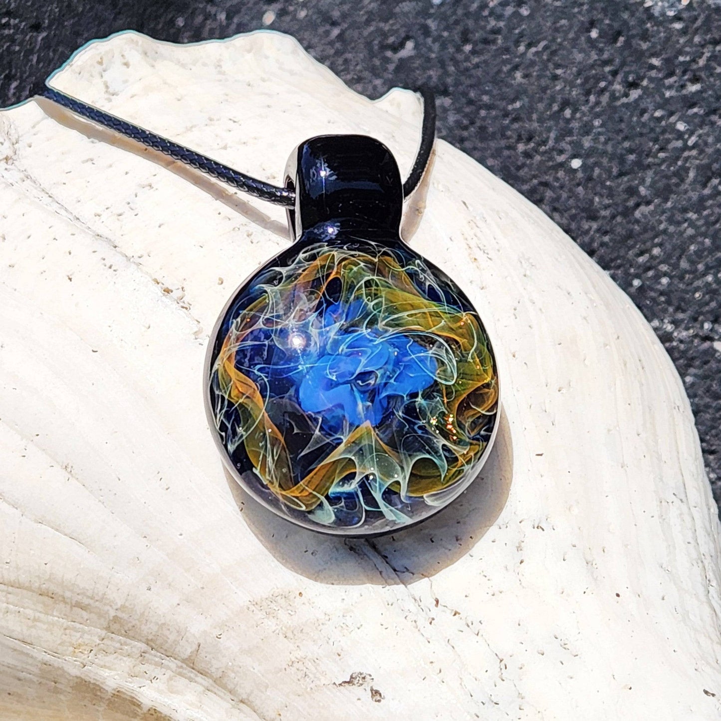 Gold and silver fumed glass pendant necklace with swirling cosmic blues and fiery gold tones, handmade for unique celestial jewelry lovers.