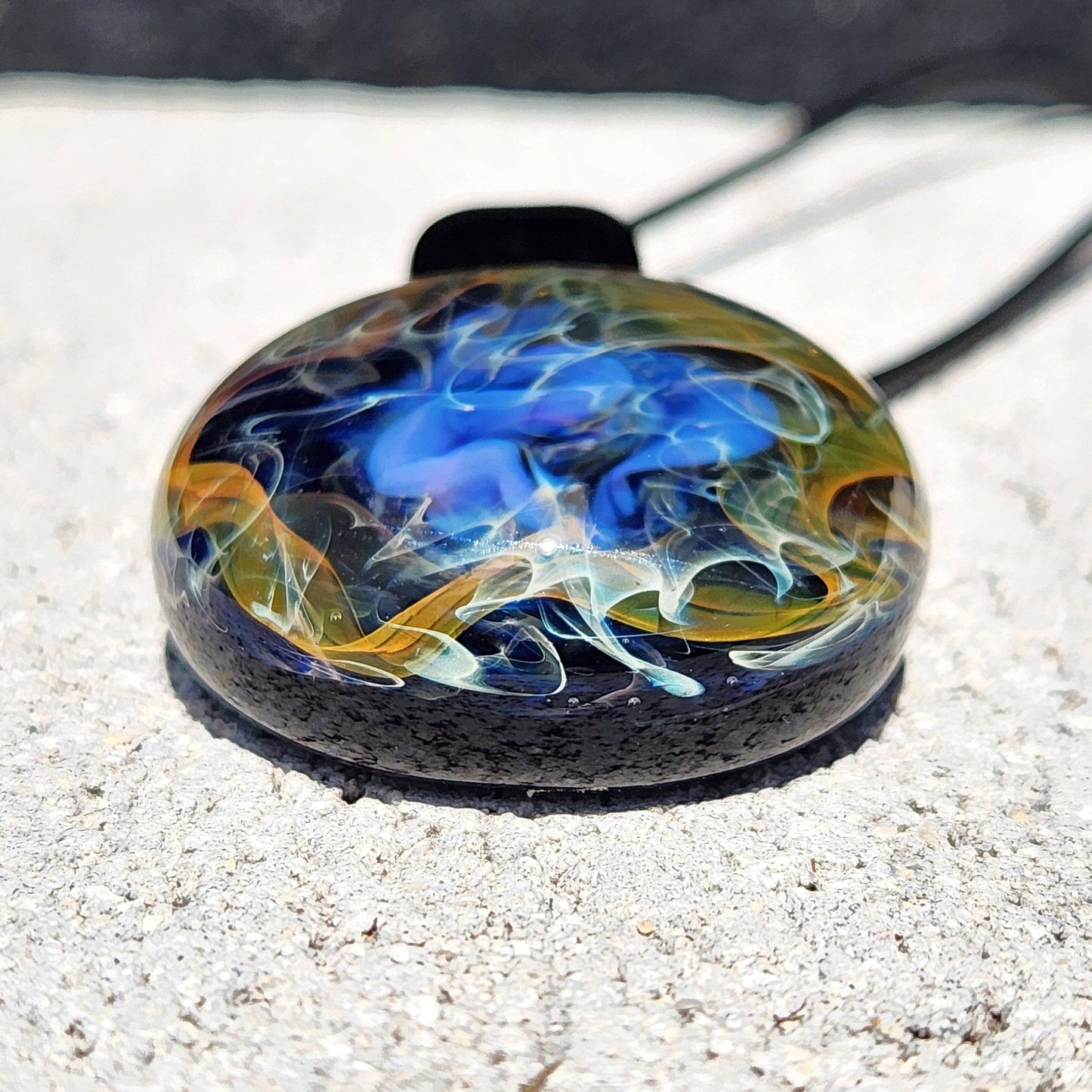 Bottom view of handmade glass pendant with layered cosmic colors in gold, silver, and blue, ideal for artistic jewelry lovers.