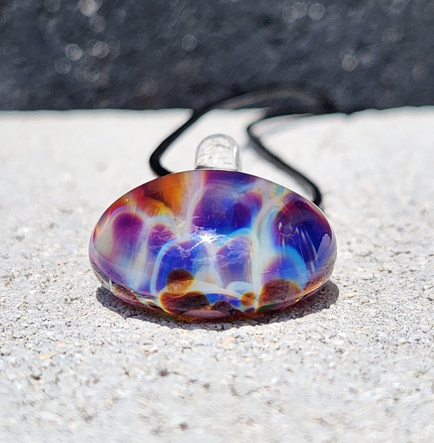 Side view of unique borosilicate glass pendant with swirling purple and blue colors, perfect for boho and artistic jewelry collections.