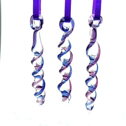 Set of 3 handmade blue and purple glass Christmas ornaments with spiral icicle design, hanging on purple ribbons as suncatchers.