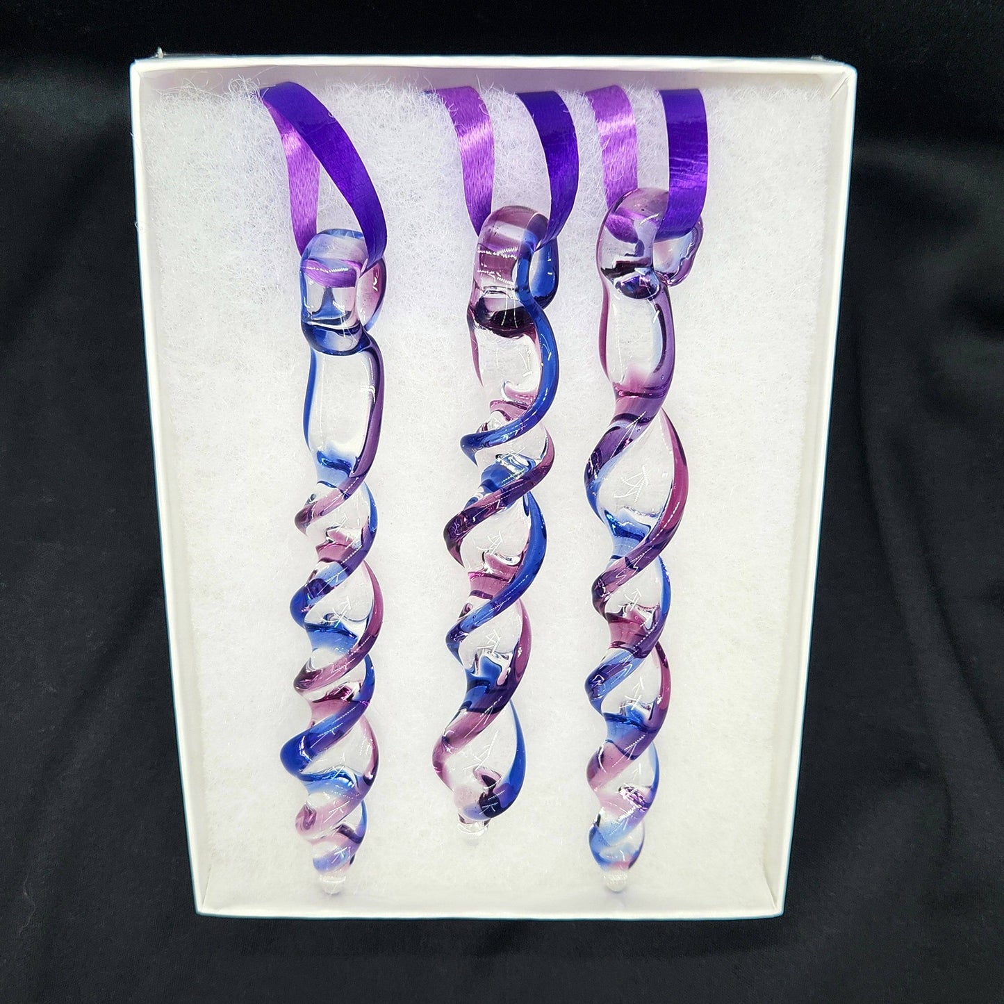 Boxed set of 3 handmade blue and purple glass Christmas ornaments with spiral icicle design, ready for gifting or seasonal display.
