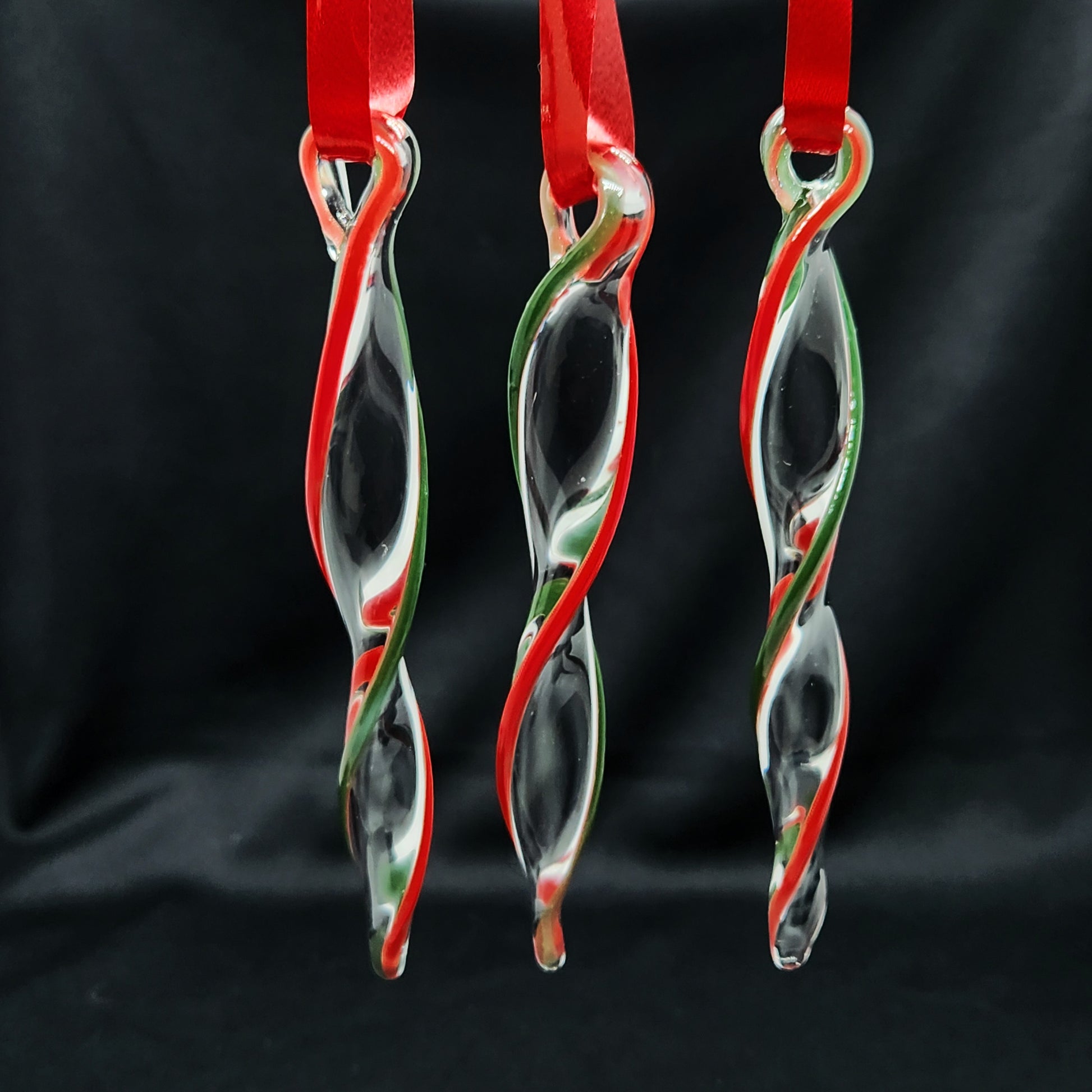 Unique handmade glass holiday ornaments in red and green swirl design, perfect for Christmas decor and festive gifts. Set of three icicle-style hangings.