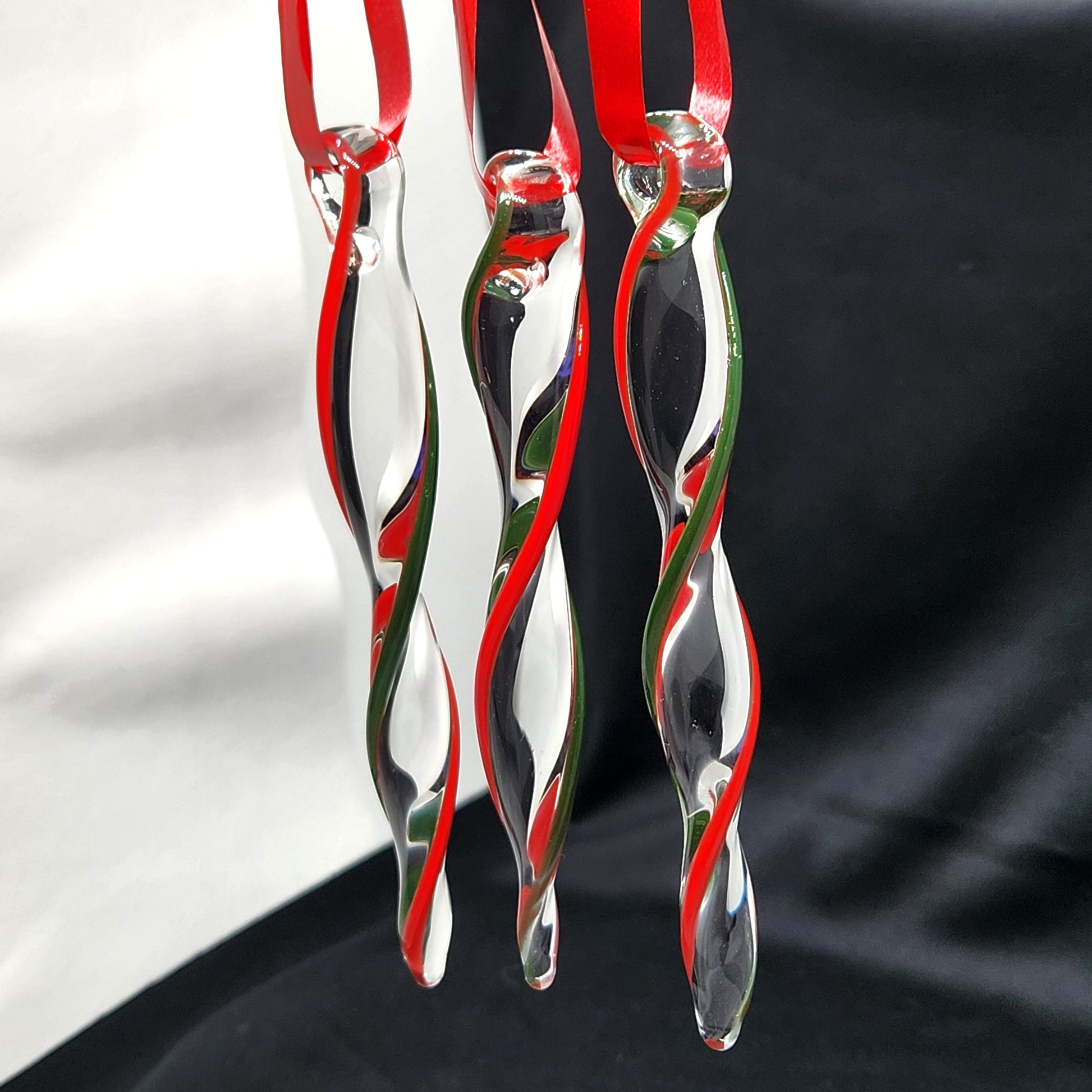 Unique handmade glass holiday ornaments in red and green swirl design, perfect for Christmas decor and seasonal gifts. Set of three icicle-style ornaments.