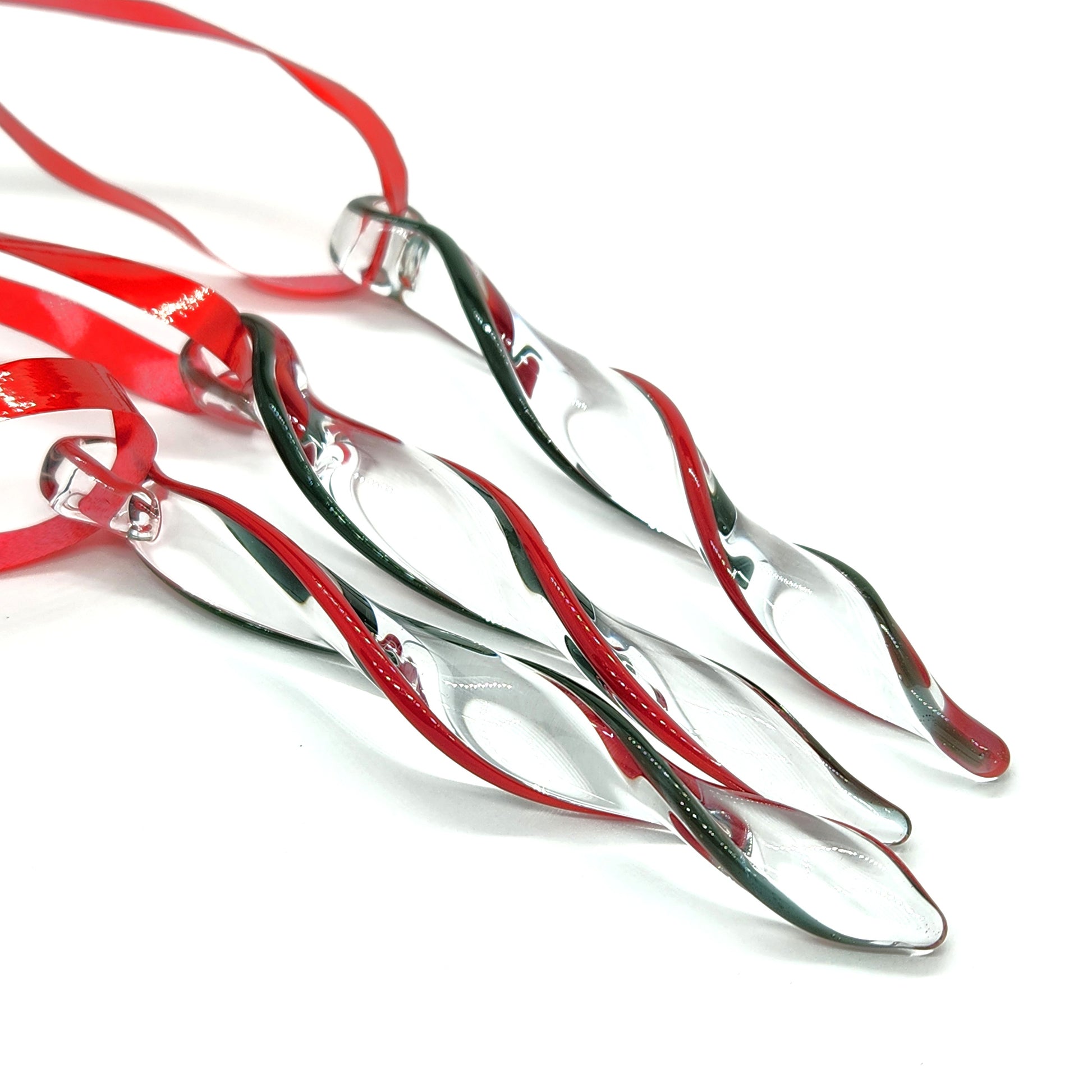 Unique handmade glass holiday ornaments in red and green twisted icicle design, perfect for Christmas decor or festive gifts.