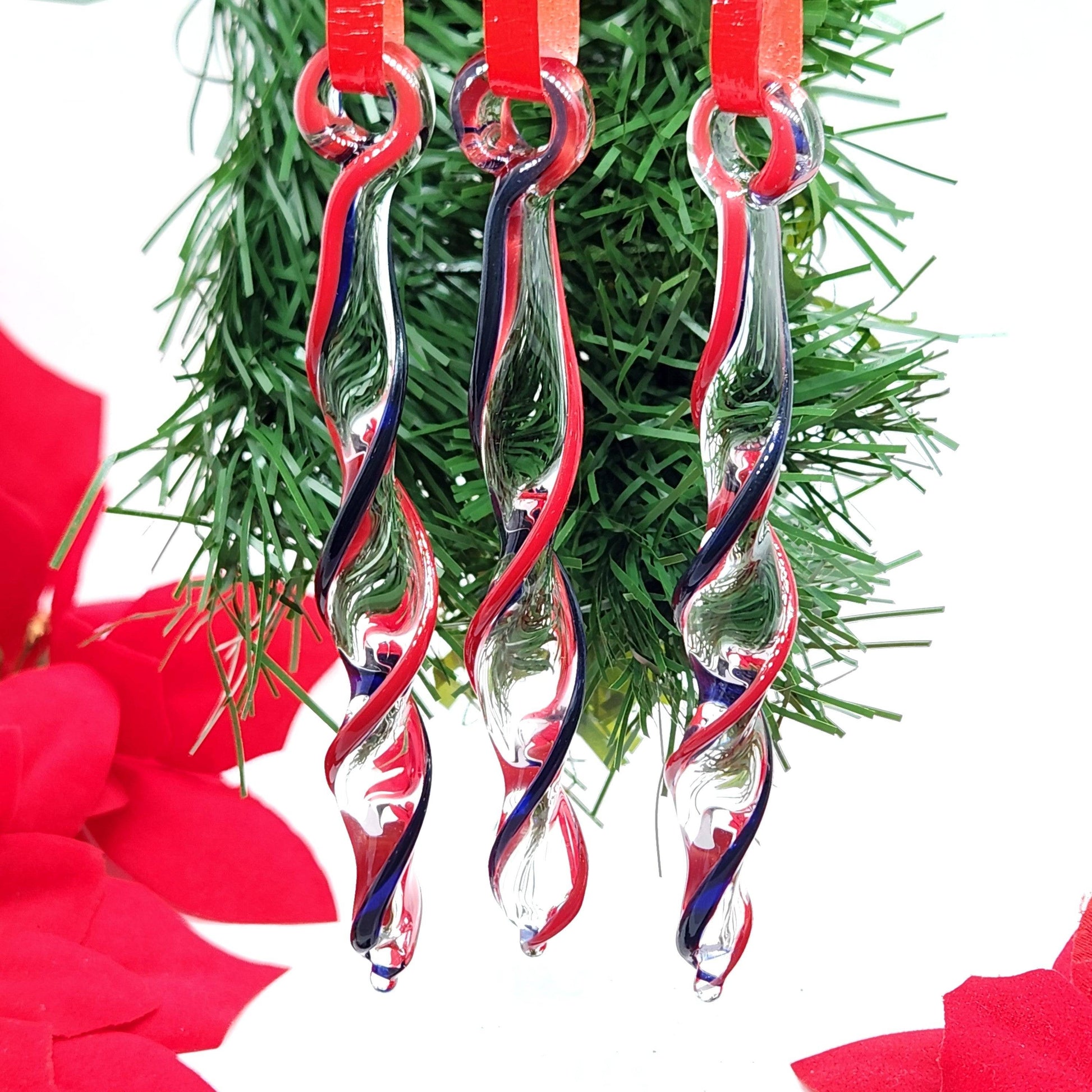 Handmade Red & Blue Glass Christmas Ornaments displayed on greenery, showcasing elegant twisted icicle design for seasonal home decor.