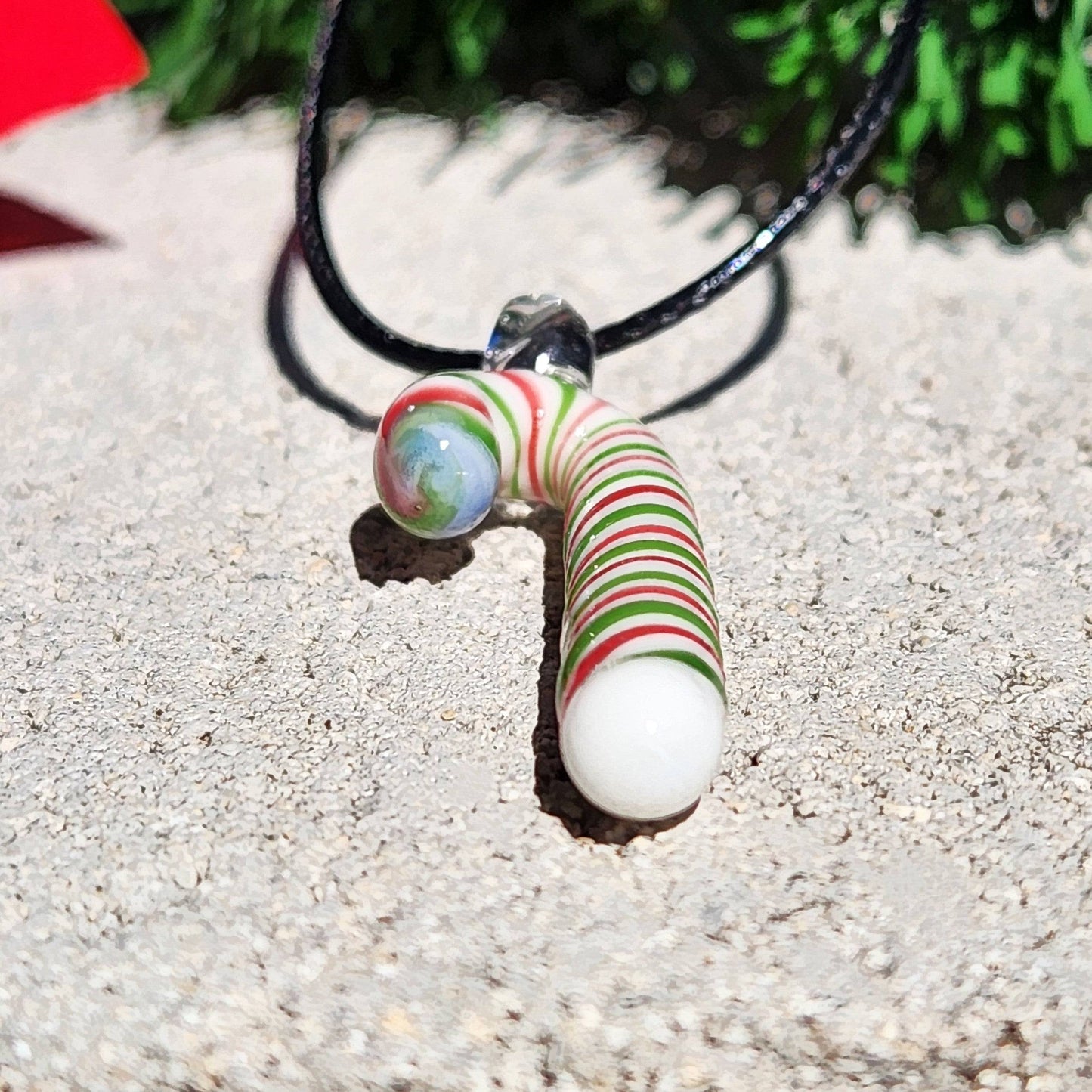 Front view of handmade glass candy cane pendant with vibrant holiday colors, ideal for Christmas jewelry gift ideas.