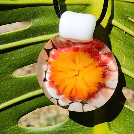 Blown Glass Flower Pendant Necklace with vibrant yellow and red bloom, displayed on a green leaf. Handmade in Florida, perfect gift jewelry.