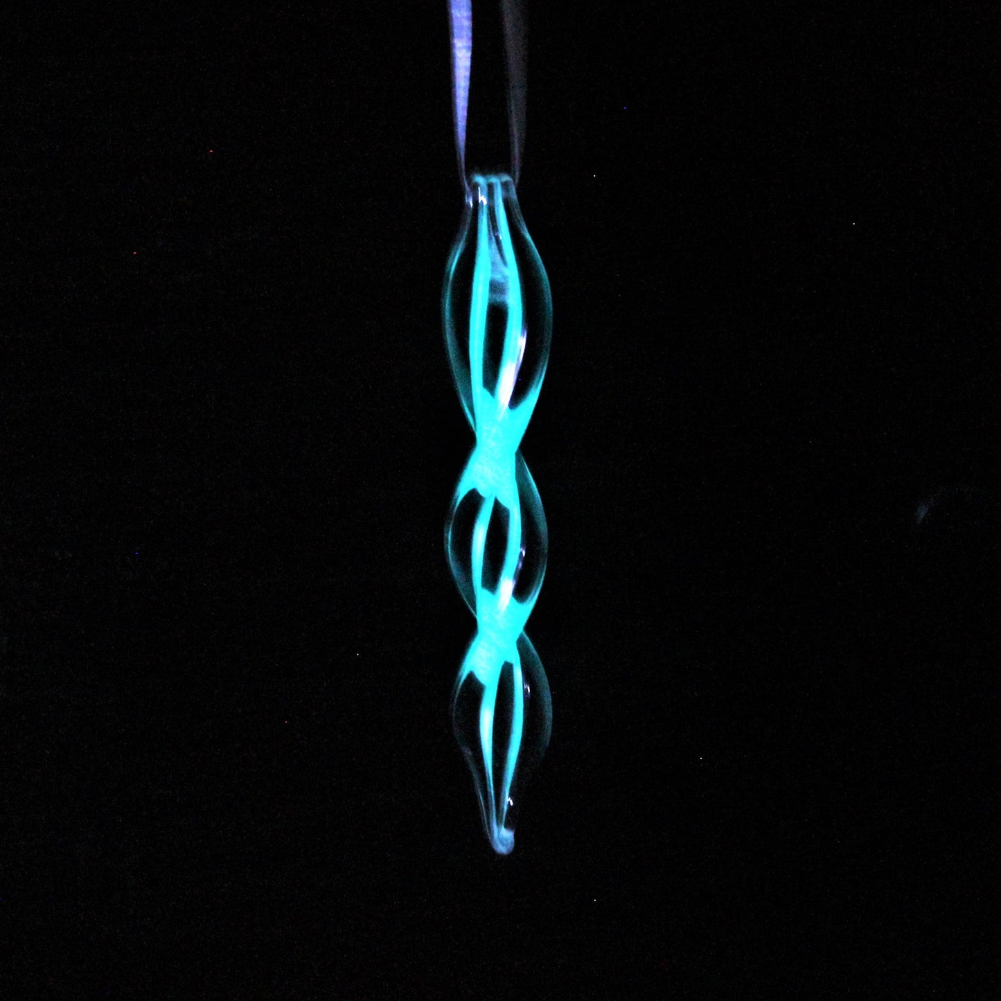 Handmade glass ornament glowing in the dark with a double helix design. Perfect for holiday gifts or seasonal home decorations.