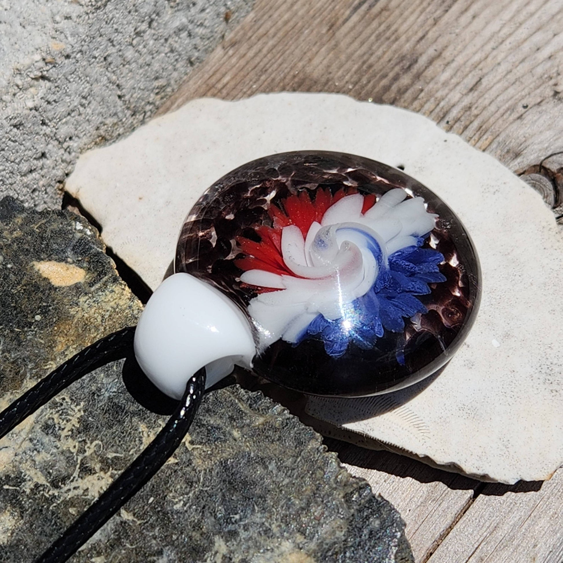 Large glass pendant featuring intricate red, white, and blue swirls in a floral pattern. Handmade borosilicate charm for statement necklaces.
