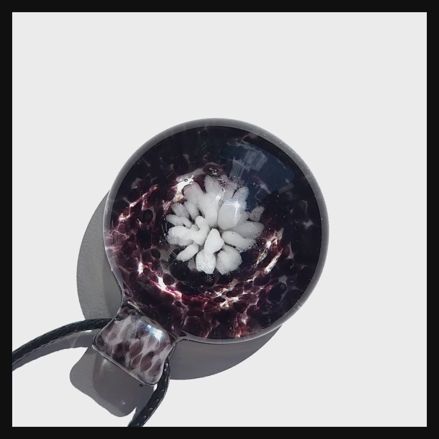 Top view of Handmade White and Black Glass Necklace pendant with crushed glass texture and white flower, ideal for unique jewelry gifts.