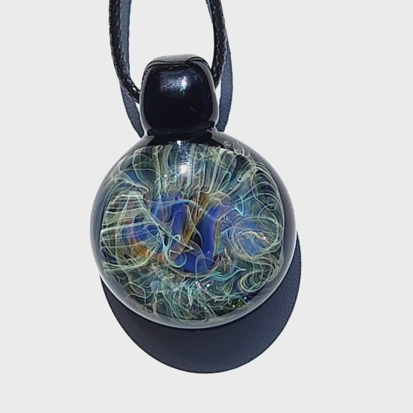 Detailed view of heady glass pendant with pure gold and silver accents in swirling galaxy design. Handmade necklace for jewelry collectors.