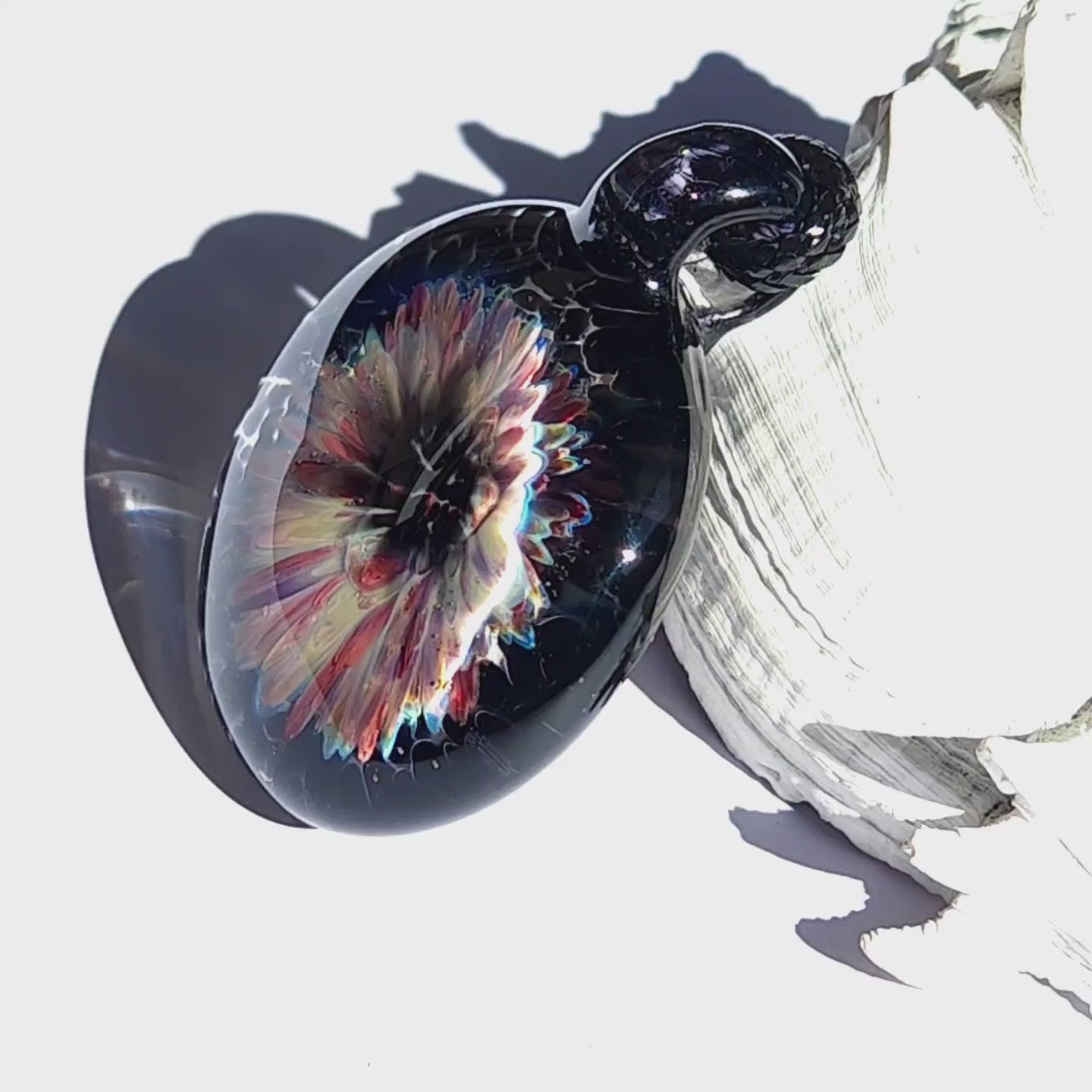 Artisan blown glass pendant necklace with a radiant floral design in cream, red, and purple hues, perfect for handmade jewelry lovers.