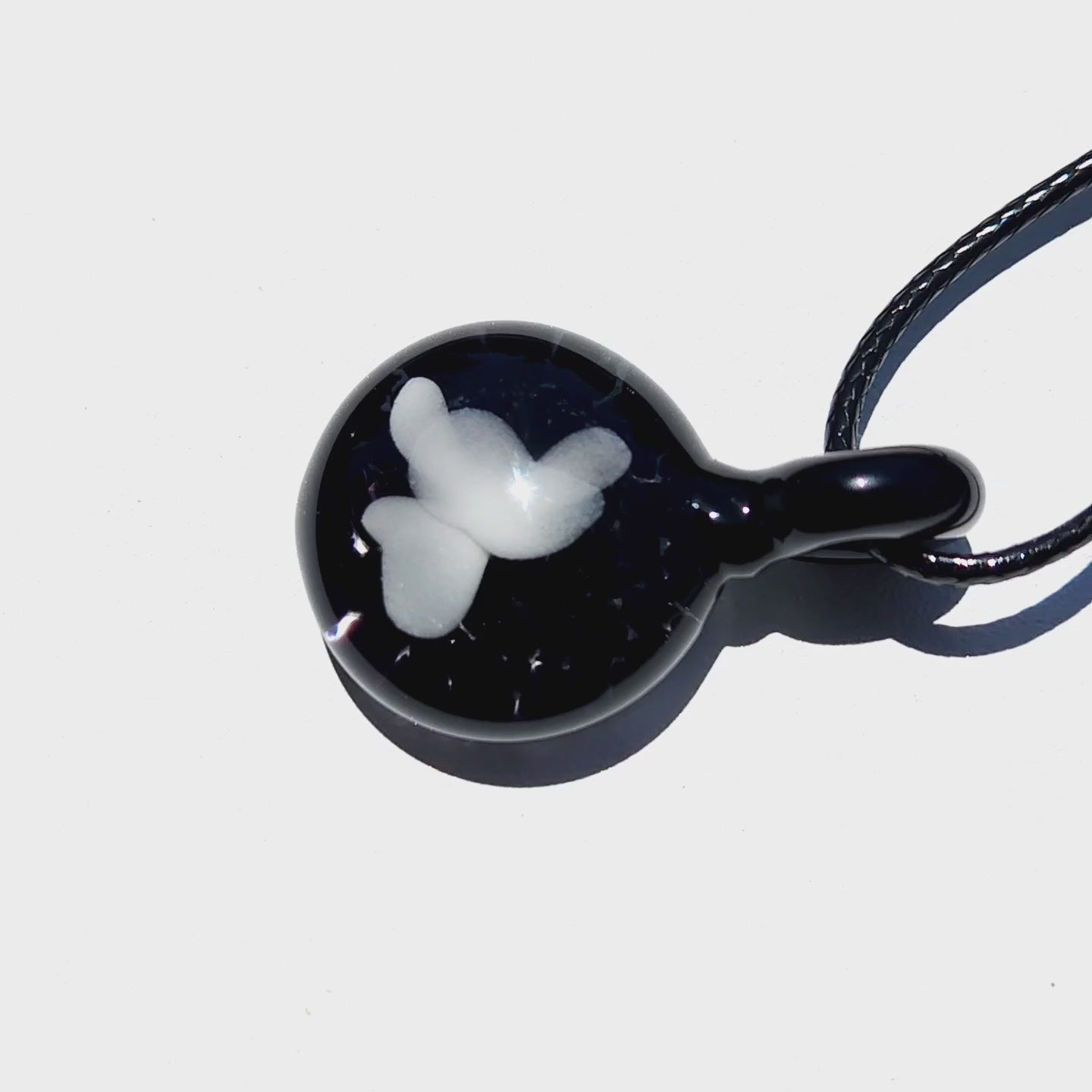 Glossy handmade black glass pendant with white butterfly design, perfect for unique jewelry collections or thoughtful gifts.