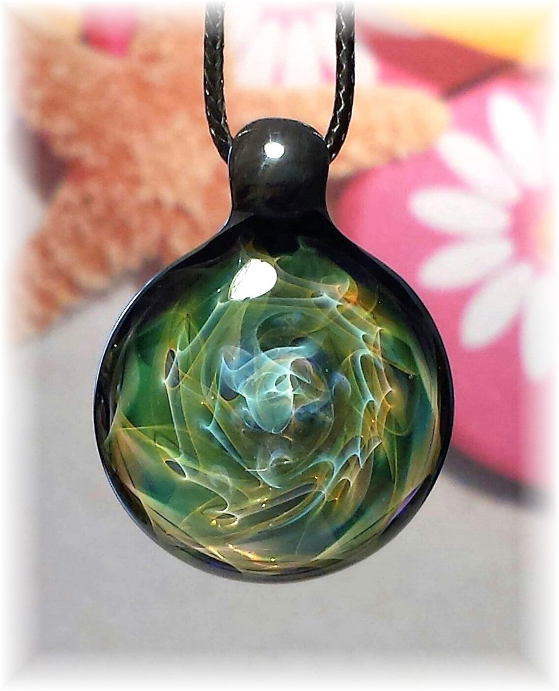 Ocean-inspired glass pendant with swirling blue and green patterns